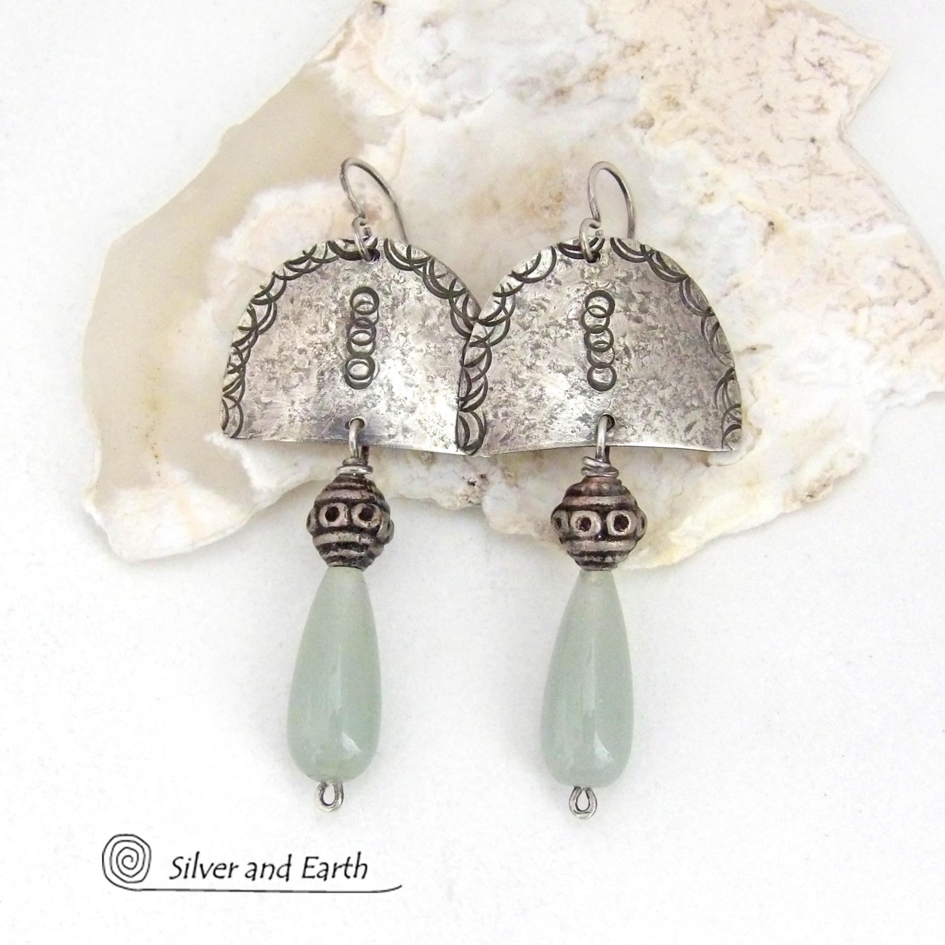These unique sterling silver earrings have a funky bohemian tribal flair. They feature handcrafted sterling silver shapes with a hand textured design accented with natural green aventurine gemstones and vintage silver beads.