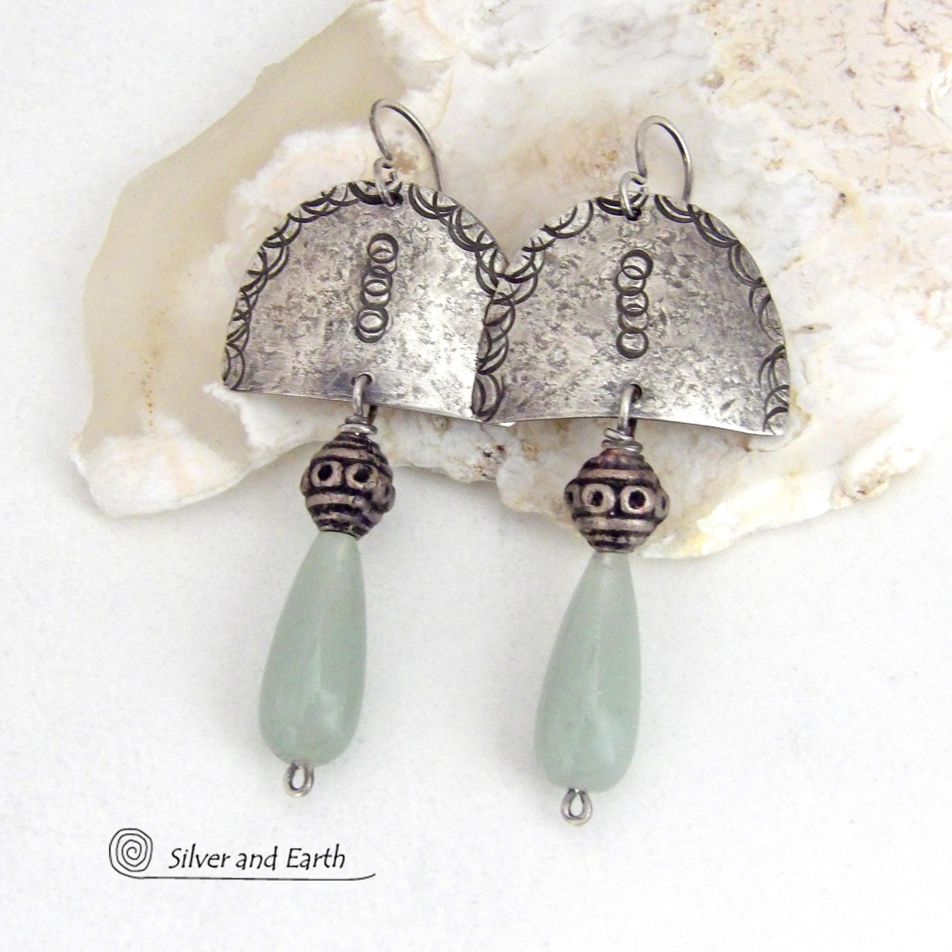 These unique sterling silver earrings have a funky bohemian tribal flair. They feature handcrafted sterling silver shapes with a hand textured design accented with natural green aventurine gemstones and vintage silver beads.