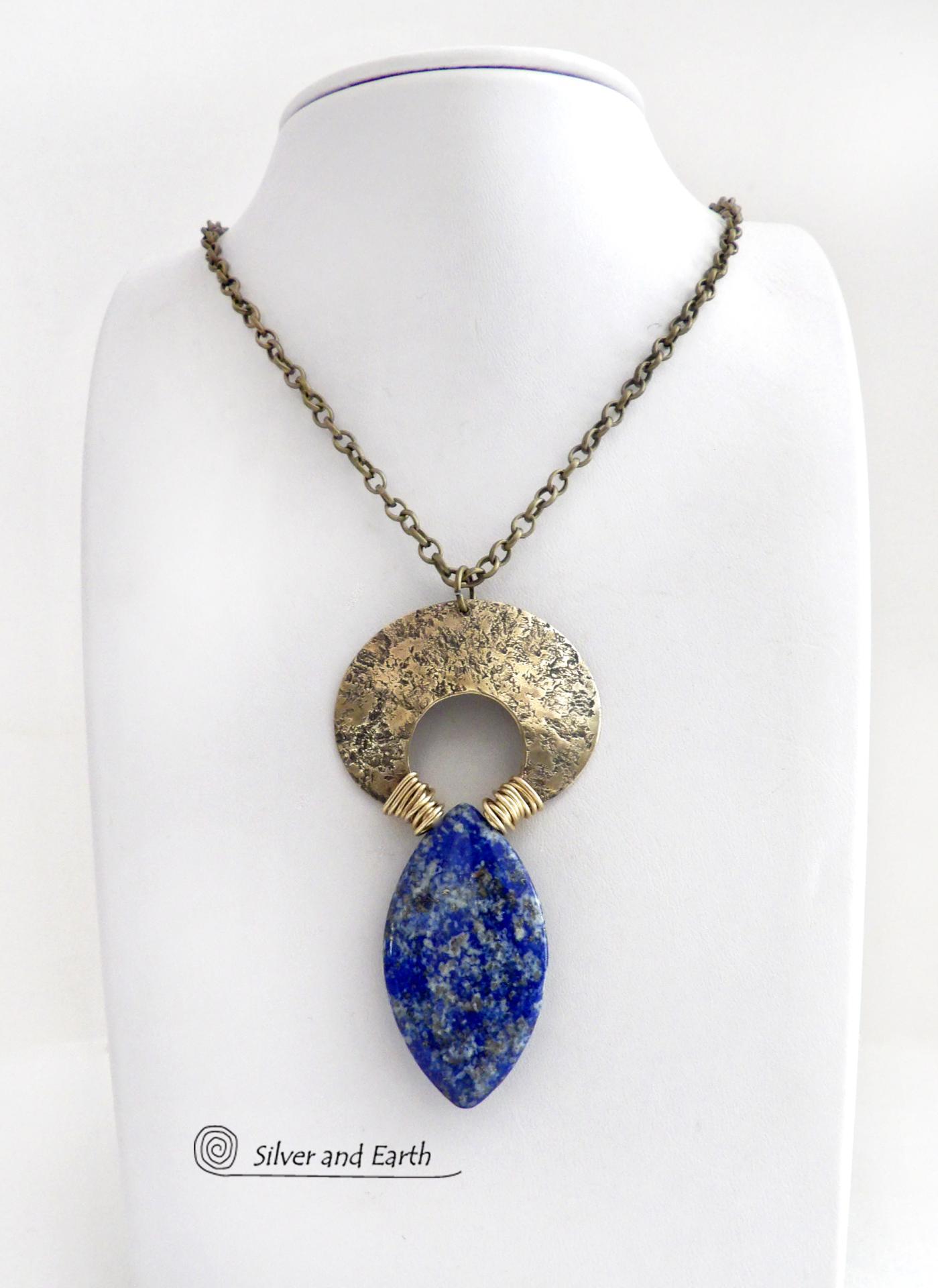 A stunning natural lapis lazuli gemstone is accented with a handcrafted gold brass crescent moon in this bold exotic necklace. The stone has a beautiful blue hue with a natural matrix of white and silvery pyrite inclusions. Unique and one-of-a-kind, it has an "Old World" Egyptian style and flair that makes a striking statement.