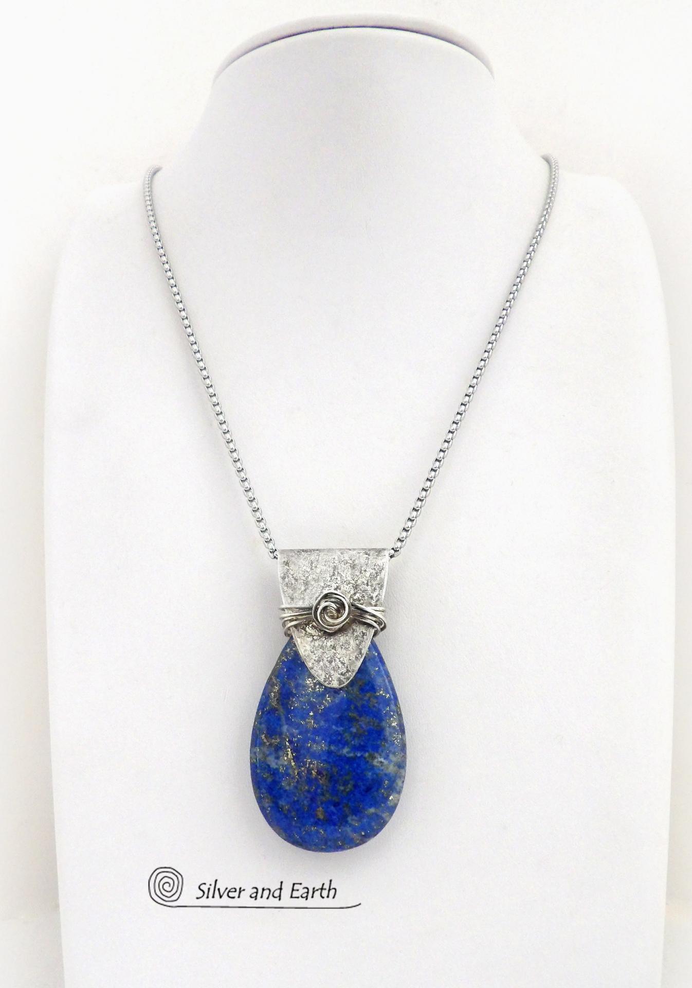 This sterling silver necklace features a natural lapis lazuli gemstone accented with a handcrafted sterling silver bail with a lightly hammered organic texture. The lapis is a beautiful shade of blue with natural sparkly pyrite inclusions.