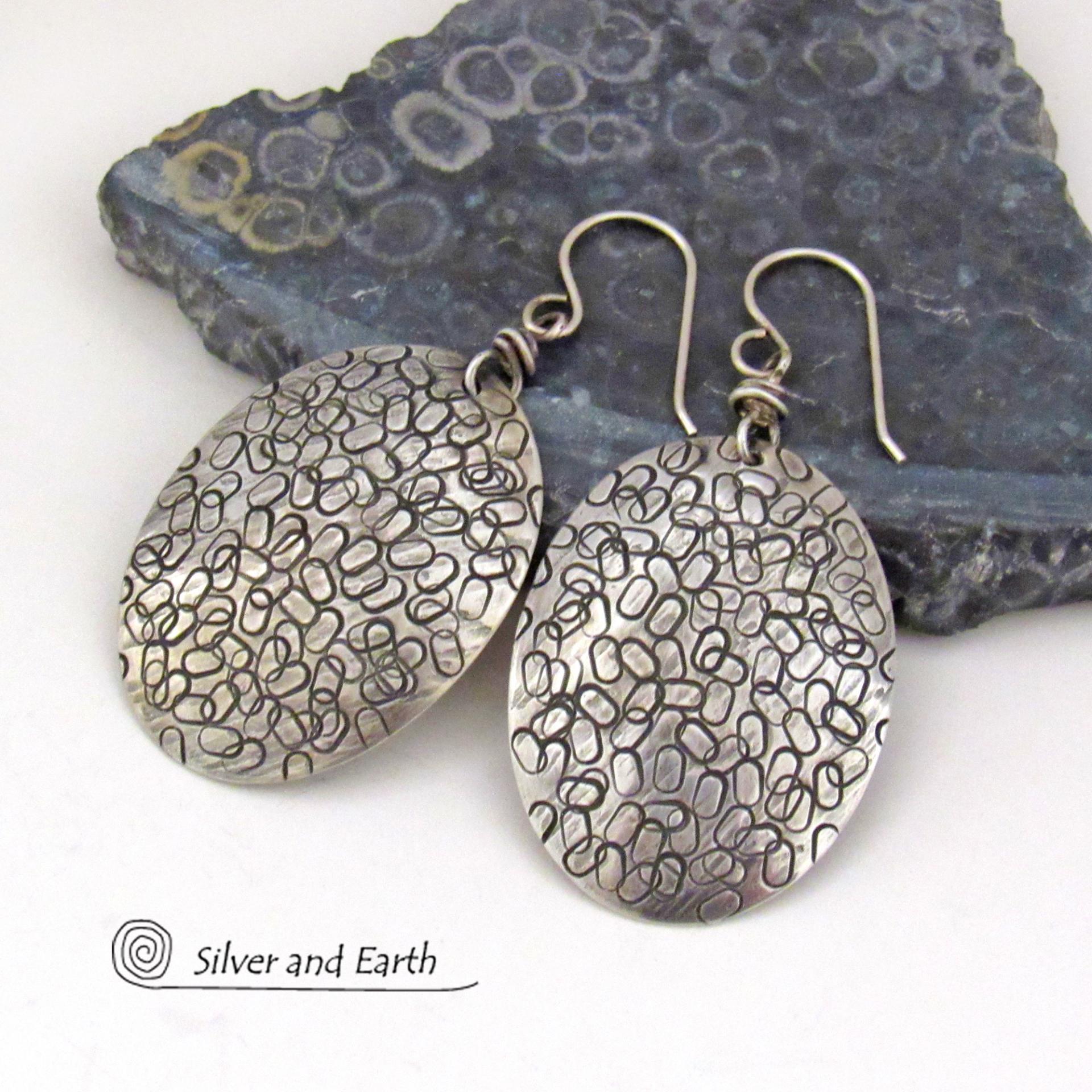 These handmade sterling silver earrings are unique and versatile. Perfect for everyday wear, they go with everything. They have a modern design with a hand stamped texture and an oxidized finish.