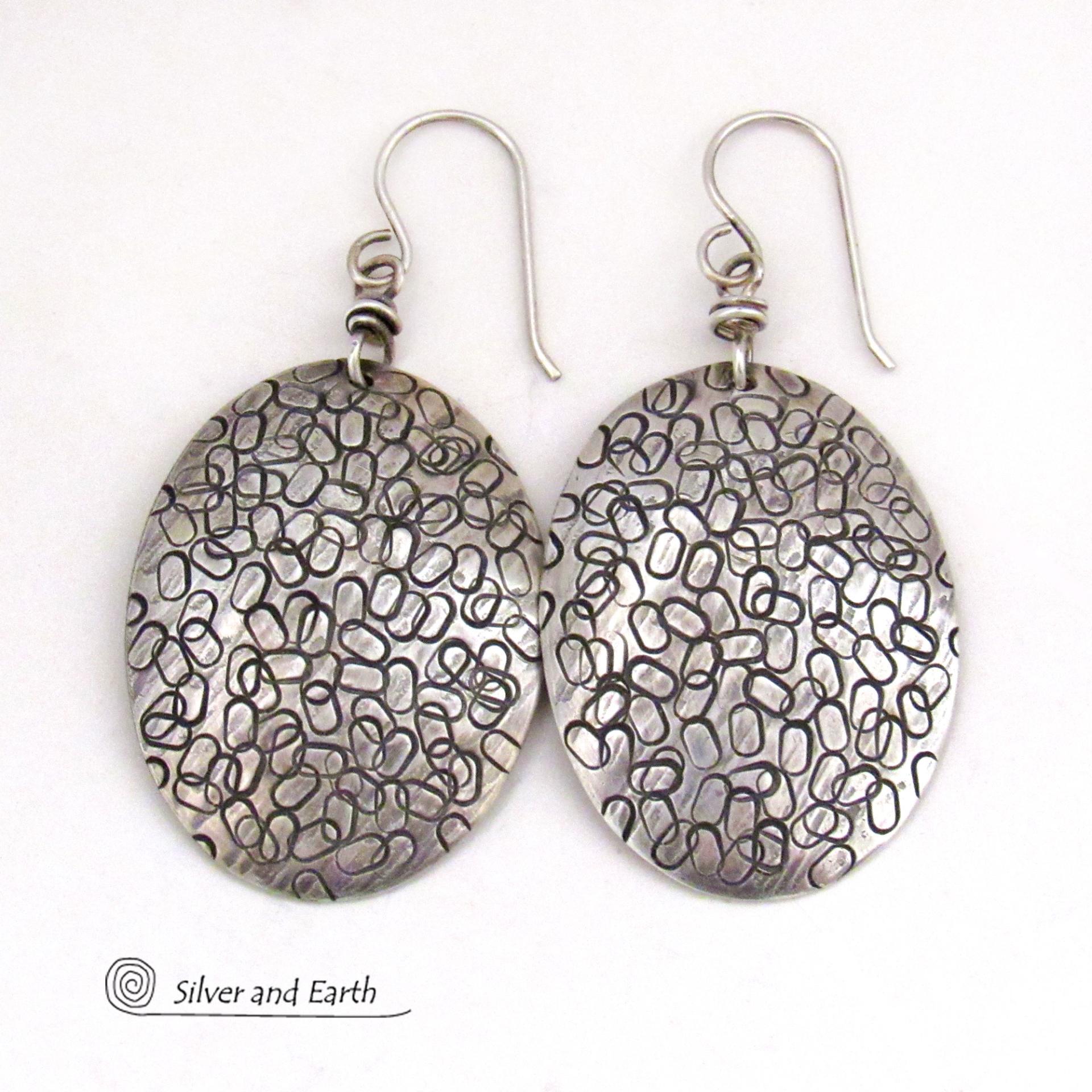These handmade sterling silver earrings are unique and versatile. Perfect for everyday wear, they go with everything. They have a modern design with a hand stamped texture and an oxidized finish.