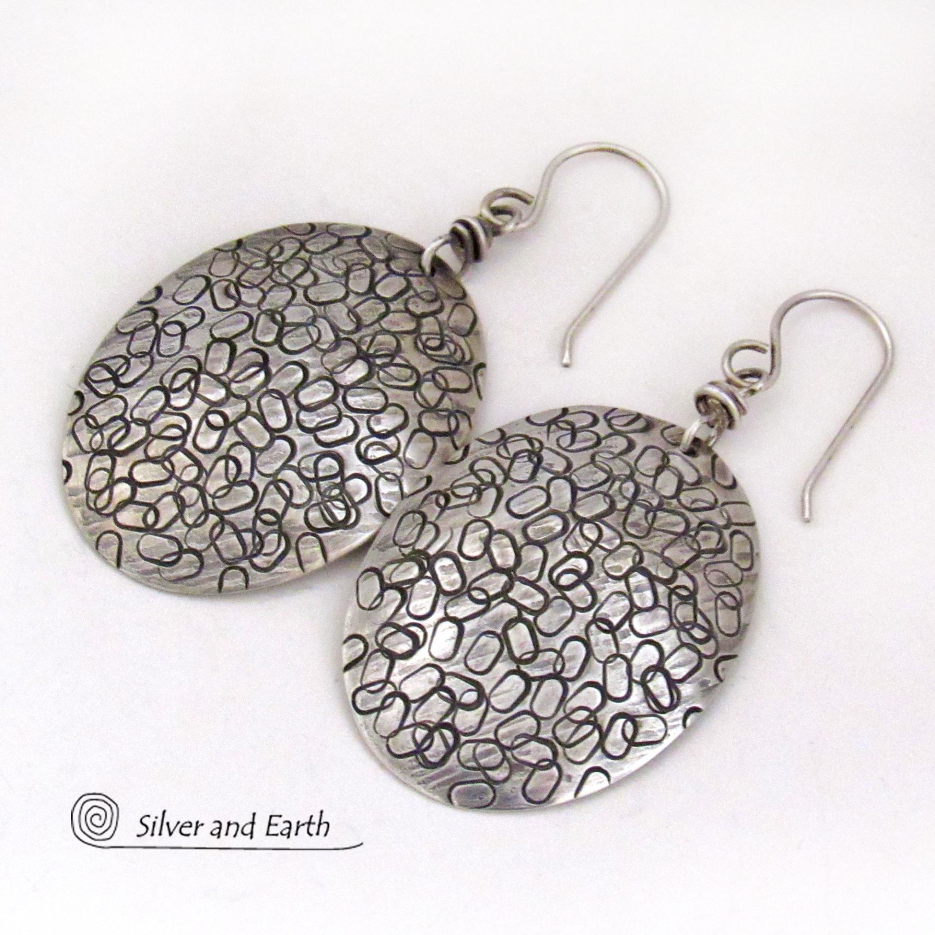 These handmade sterling silver earrings are unique and versatile. Perfect for everyday wear, they go with everything. They have a modern design with a hand stamped texture and an oxidized finish.