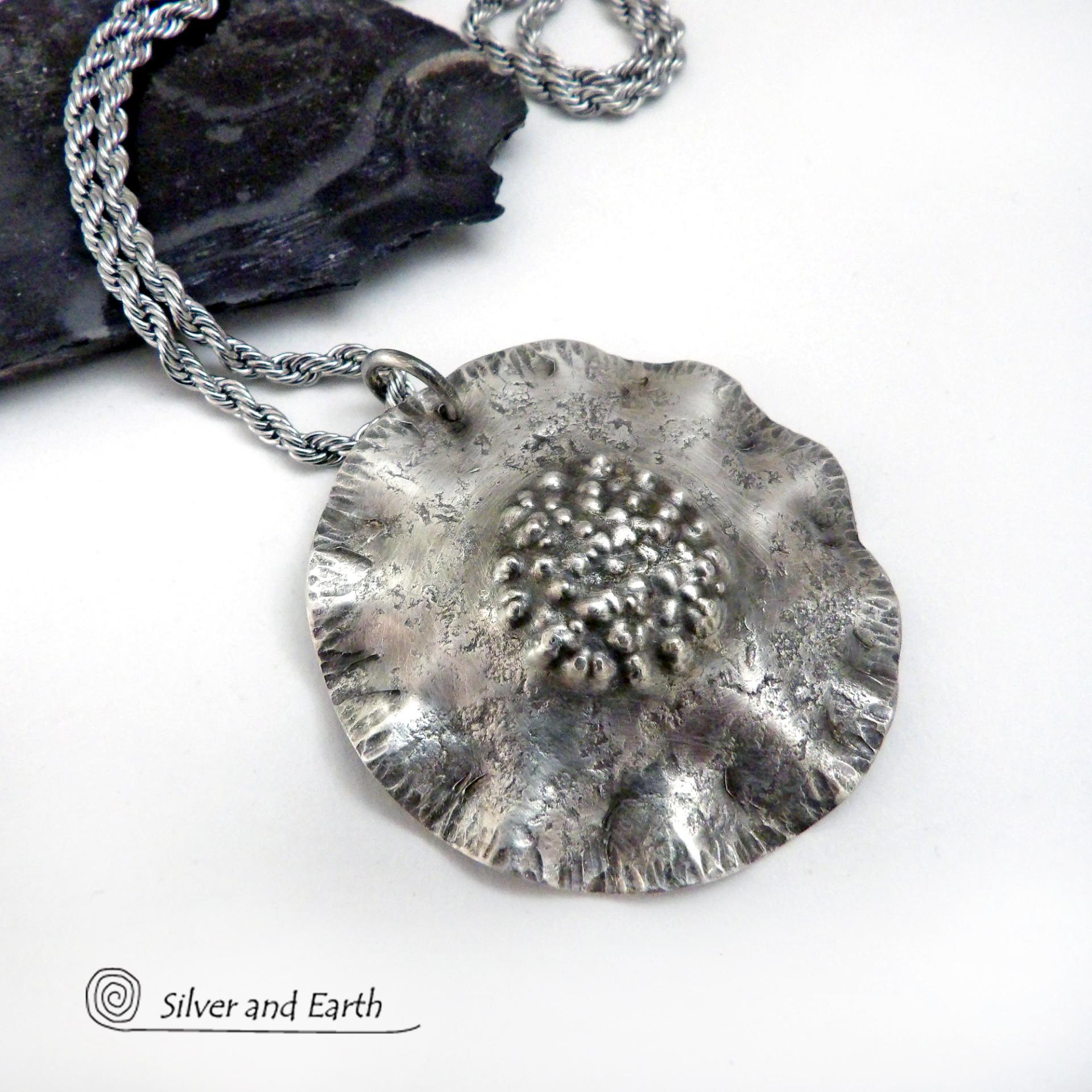 This handcrafted sterling silver necklace has a modern, earthy organic vibe. Perfect for everyday wear - it goes with everything. It features a large sterling silver circle with a rustic, hand forged texture and crimped ruffled edges.  Big and bold, it's sure to make an eye-catching statement. Handmade in the USA by Silver and Earth, a New Mexico True Certified business.  