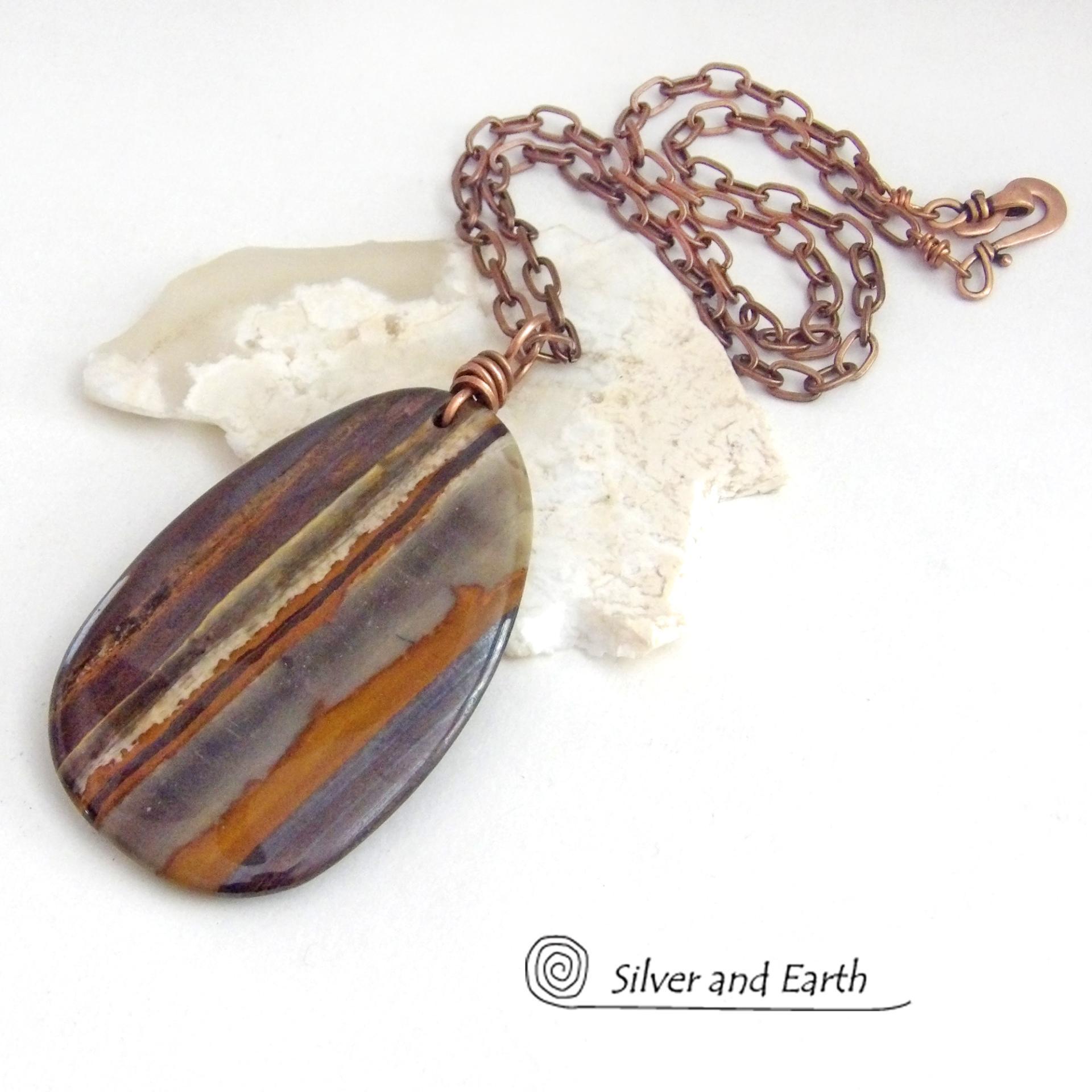 Big and bold, this one of a kind pendant necklace features a large natural tiger iron gemstone with a copper wire bail. The stone has beautiful earthy hues of various shades of brown, smoky grey, rust and creamy bands of white. It's a gorgeous stone with a nice high polish. Sure to make a striking statement, it'll make a great gift for a natural stone lover.