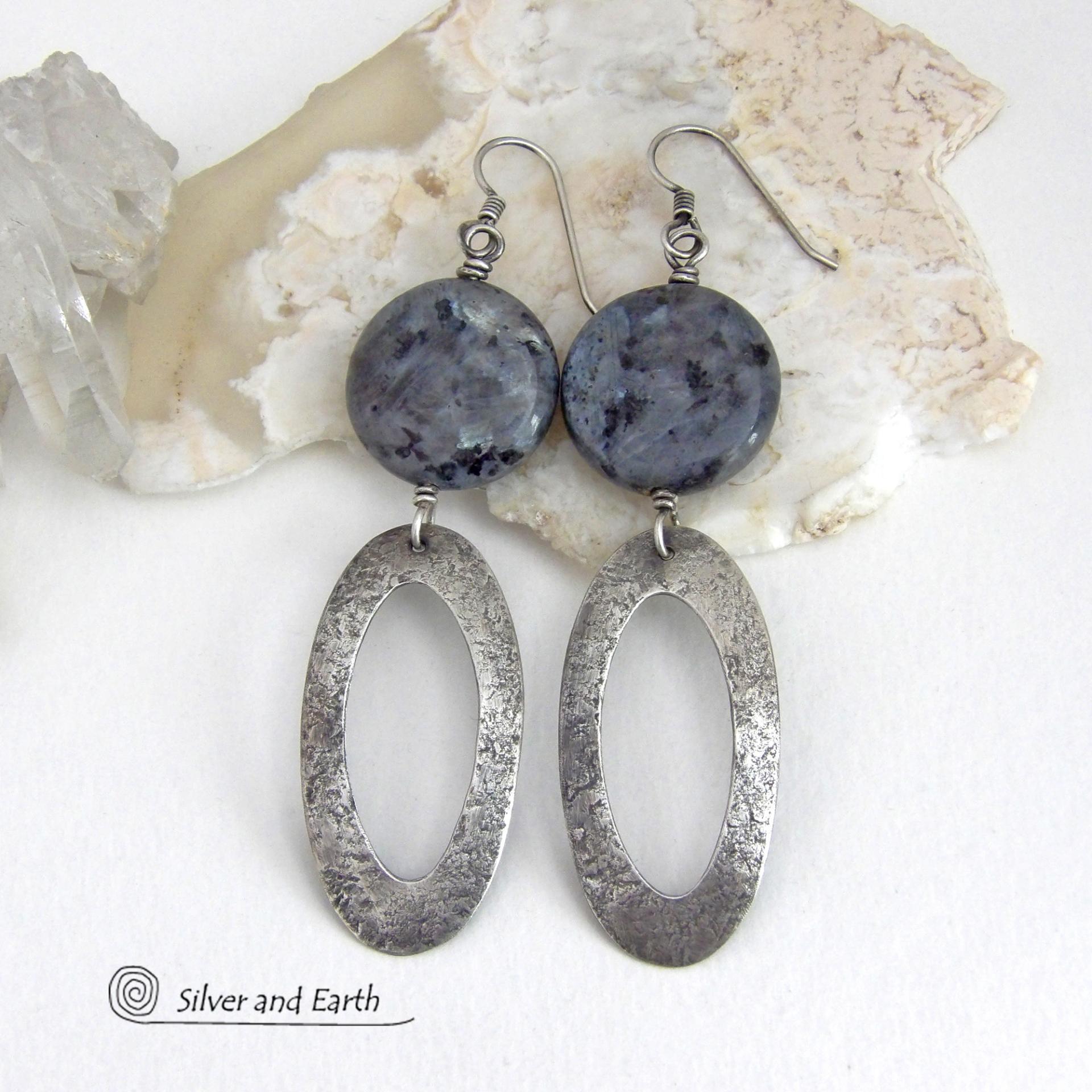 Modern, earthy & chic - these earrings feature big round natural larvikite gemstones accented with long sterling silver hoop dangles. The stones have a pearly, grayish black hue - along with blue iridescent flashes of light which cast off a natural shimmer & shine. They have a modern, contemporary style that coordinates beautifully with all wardrobe types. Larvikite originates from the Larvik region in Norway and is also called Norwegian moonstone and black labradorite. 