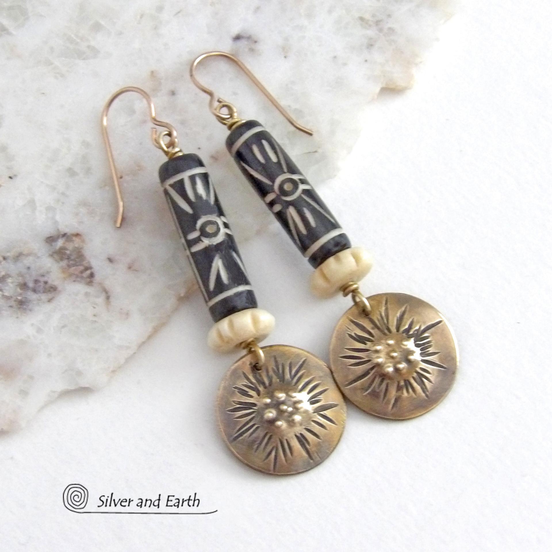 These handcrafted earrings feature African batik carved bone beads accented with textured gold brass dangles and carved bone beads. They have a boho chic tribal flair that will make a striking statement. Perfect for women that love to wear bold unique jewelry. Handmade in the USA by Silver and Earth Jewelry. 