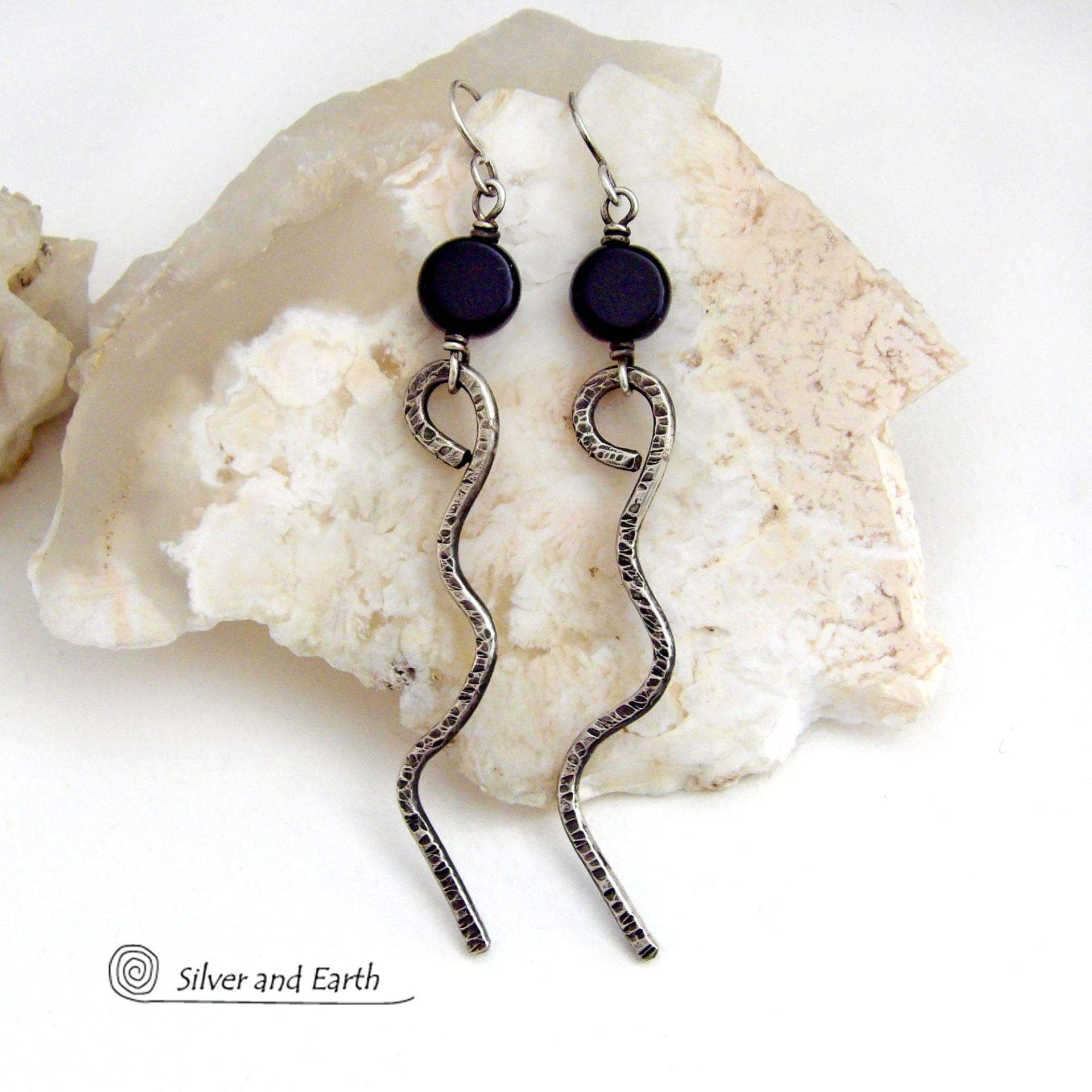 These handcrafted earrings have a contemporary modern and minimalist vibe. They feature hand forged solid sterling silver curvy sticks with a hammered organic texture topped off with coin-shaped black onyx gemstones.  Lightweight and fun to wear, they'll coordinate with all wardrobe styles and make a unique statement. Total length of approximately 3-1/4" from top of sterling silver ear wires and 3/8” at widest point of stone.