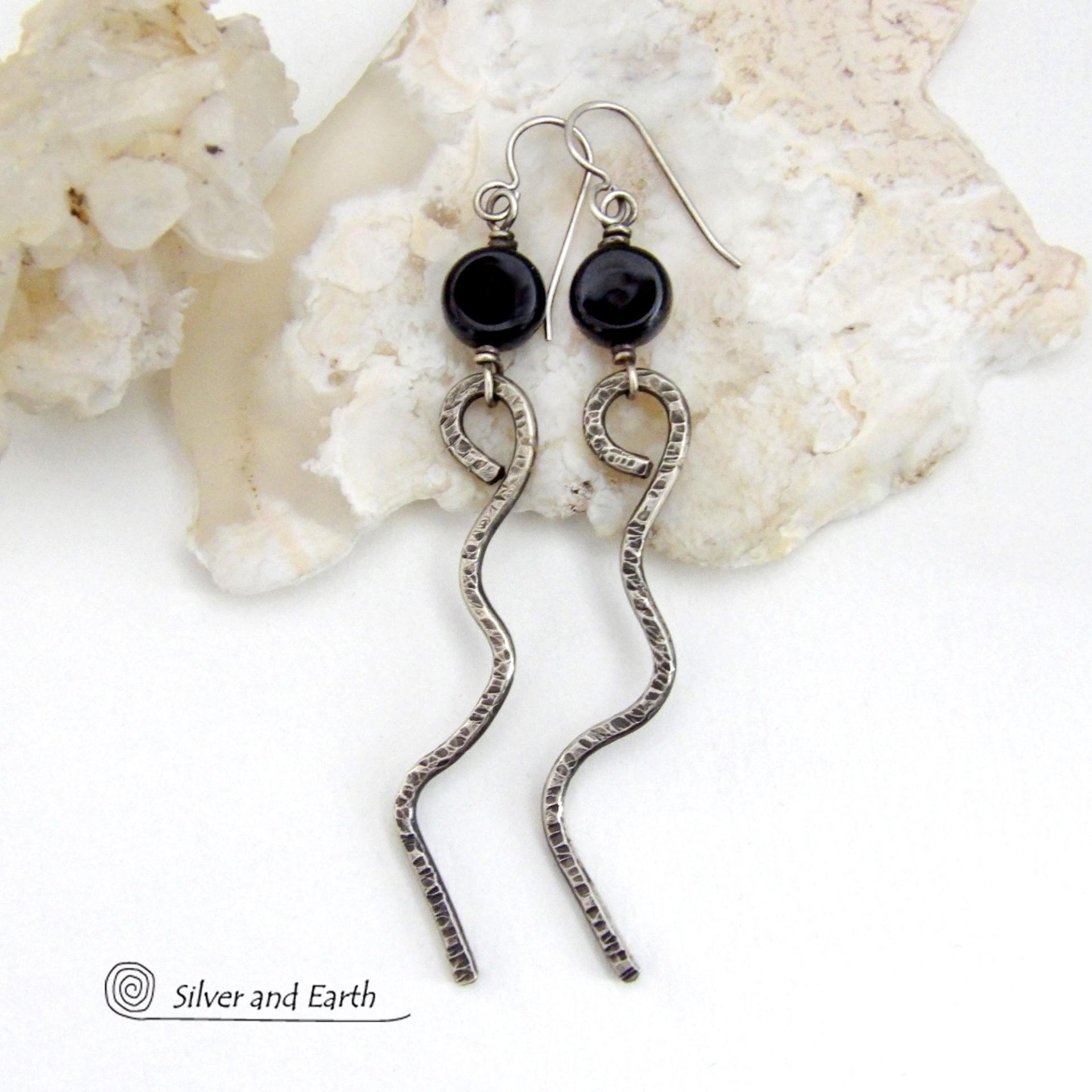 These handcrafted earrings have a contemporary modern and minimalist vibe. They feature hand forged solid sterling silver curvy sticks with a hammered organic texture topped off with coin-shaped black onyx gemstones.  Lightweight and fun to wear, they'll coordinate with all wardrobe styles and make a unique statement. Total length of approximately 3-1/4" from top of sterling silver ear wires and 3/8” at widest point of stone.