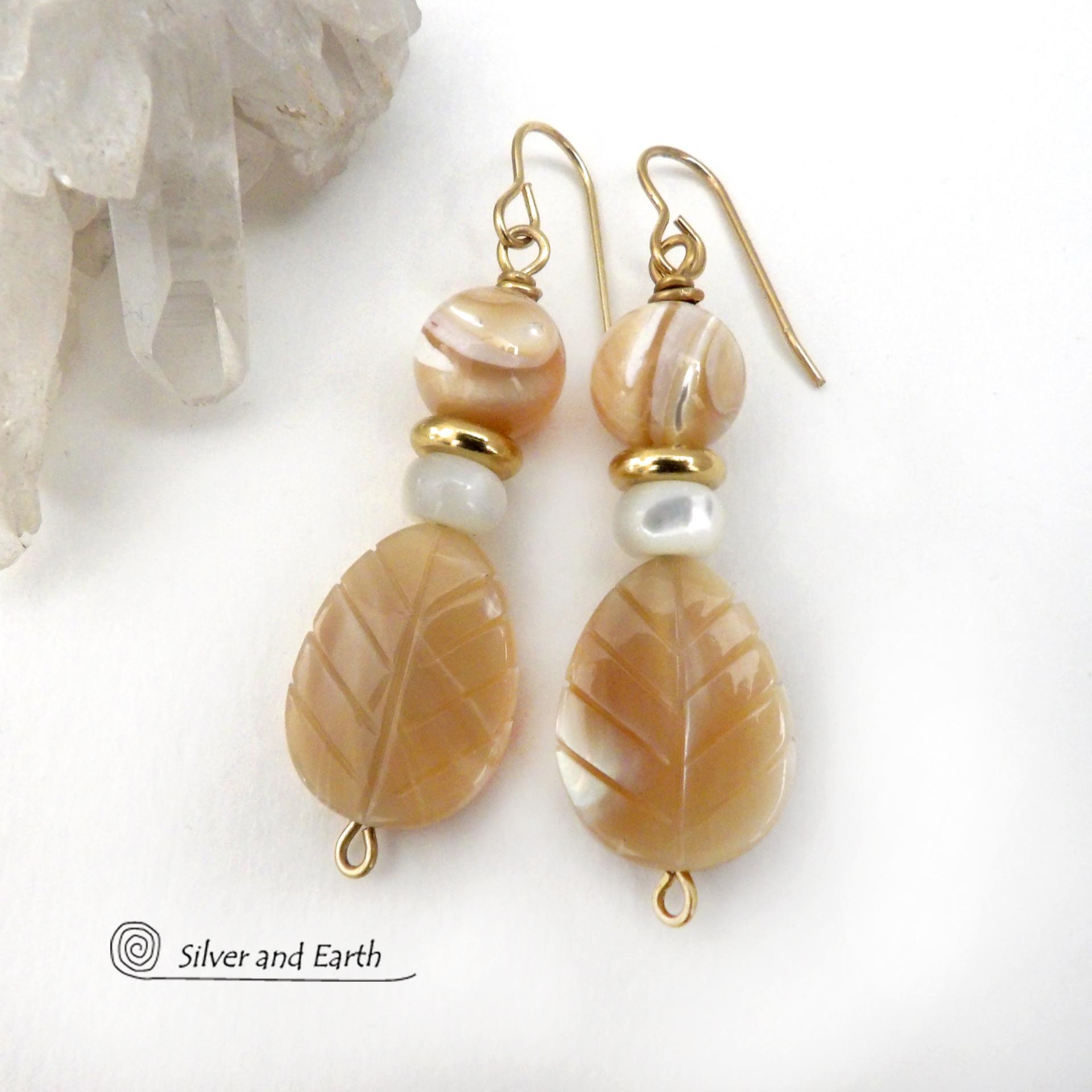 These handcrafted earrings feature golden Mother-of-Pearl carved leaf beads accented with small Mother-of-Pearl beads, shiny gold brass beads and topped off with round golden Mother-of-Pearl beads. The Mother-of-Pearl has a natural shimmery hue which casts off a beautiful shine. They have an elegant, modern style that will look great dressed up or down. They'll make a great gift for a nature lover. Handmade in the USA by Silver and Earth Jewelry.