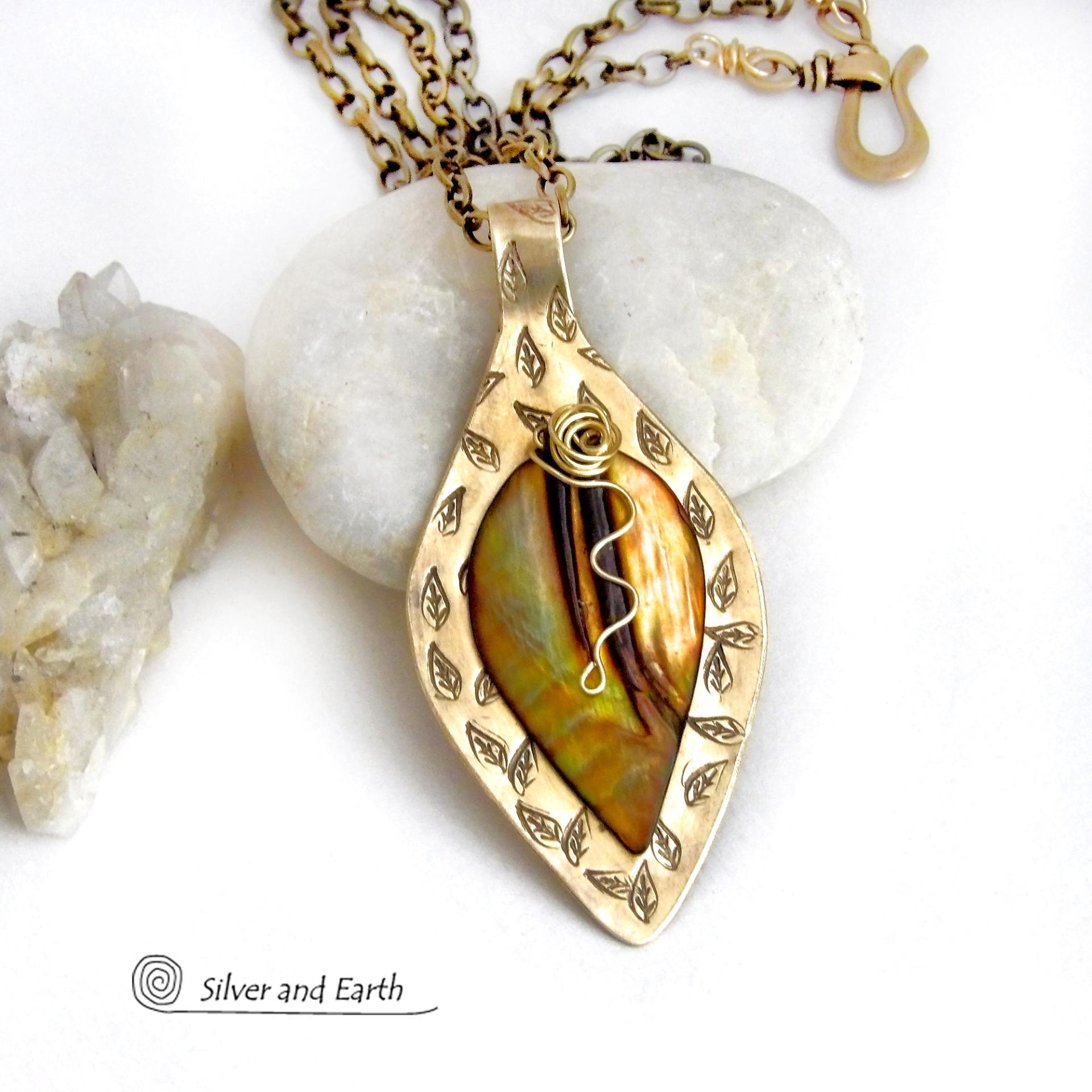 This necklace features a golden brown carved Mother of Pearl leaf accented against a handcrafted gold brass base. I hand sawed the base out of solid gold brass sheet and stamped the metal with a leaf pattern to "echo" the Mother of Pearl leaf. Unique and one-of-kind, it'll make a great gift for a nature lover - or a nice addition to your own jewelry wardrobe. It comes on an 18" antiqued brass chain with lobster claw closure. Handmade in the USA by Silver and Earth Jewelry. 
