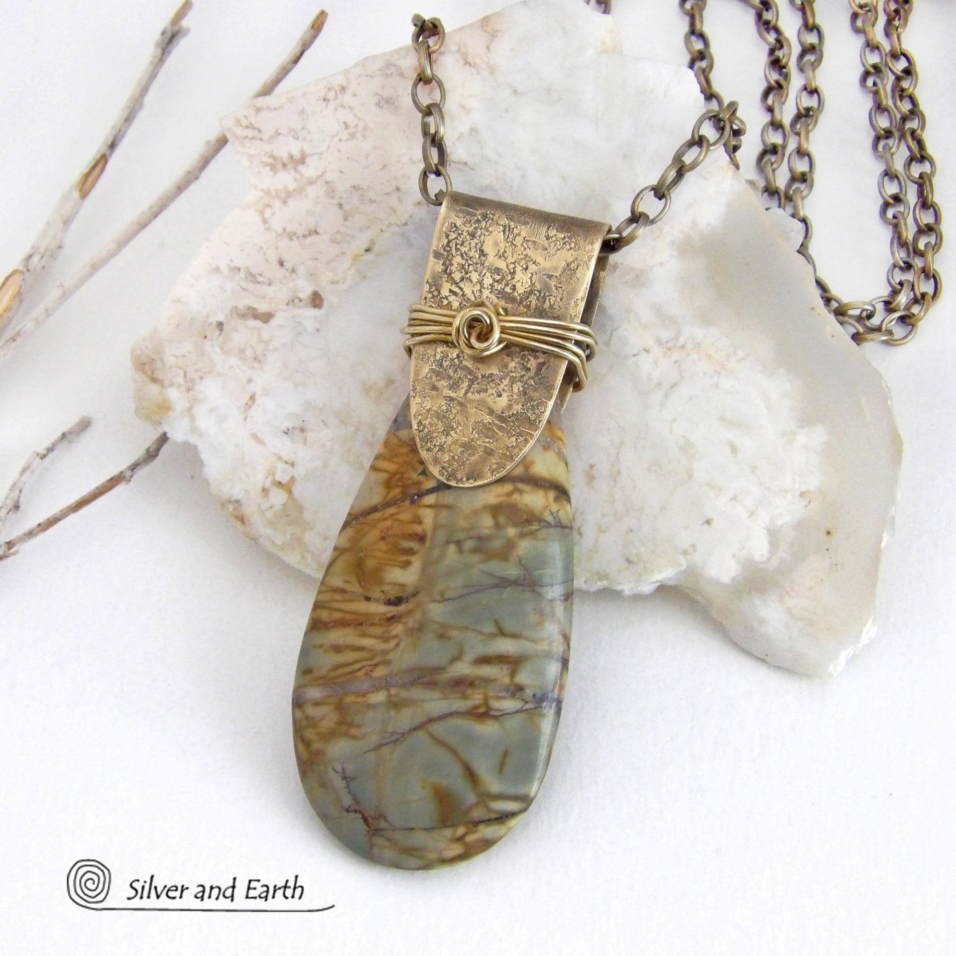 This handcrafted necklace features a natural Picasso jasper gemstone accented with a gold brass bail. The stone has a beautiful matrix with earthy hues of soft yellow, light mossy green and brown streaks. It has an earthy, modern style that coordinates beautifully with all wardrobe types. Unique and one of a kind, it makes a great gift for a natural stone lover - or a nice addition to your own jewelry collection. Comes on a 20" antiqued brass chain with lobster claw closure. 