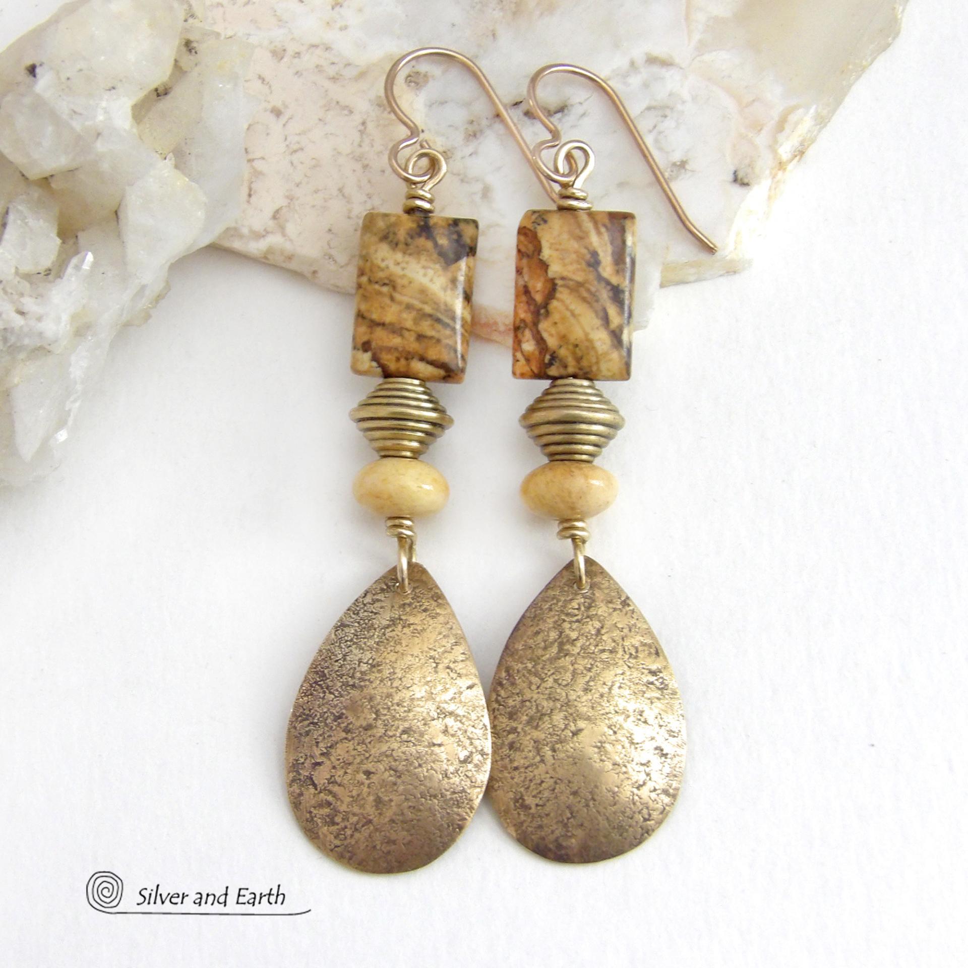 These handcrafted earrings feature gold brass teardrop dangles with a lightly hammered organic texture accented with natural picture jasper stones, brass and fossilized beige coral beads. They have an earthy natural style that coordinates beautifully with all wardrobe styles. Earrings have a coordinating necklace sold separately. Handmade in the USA by Silver and Earth Jewelry.