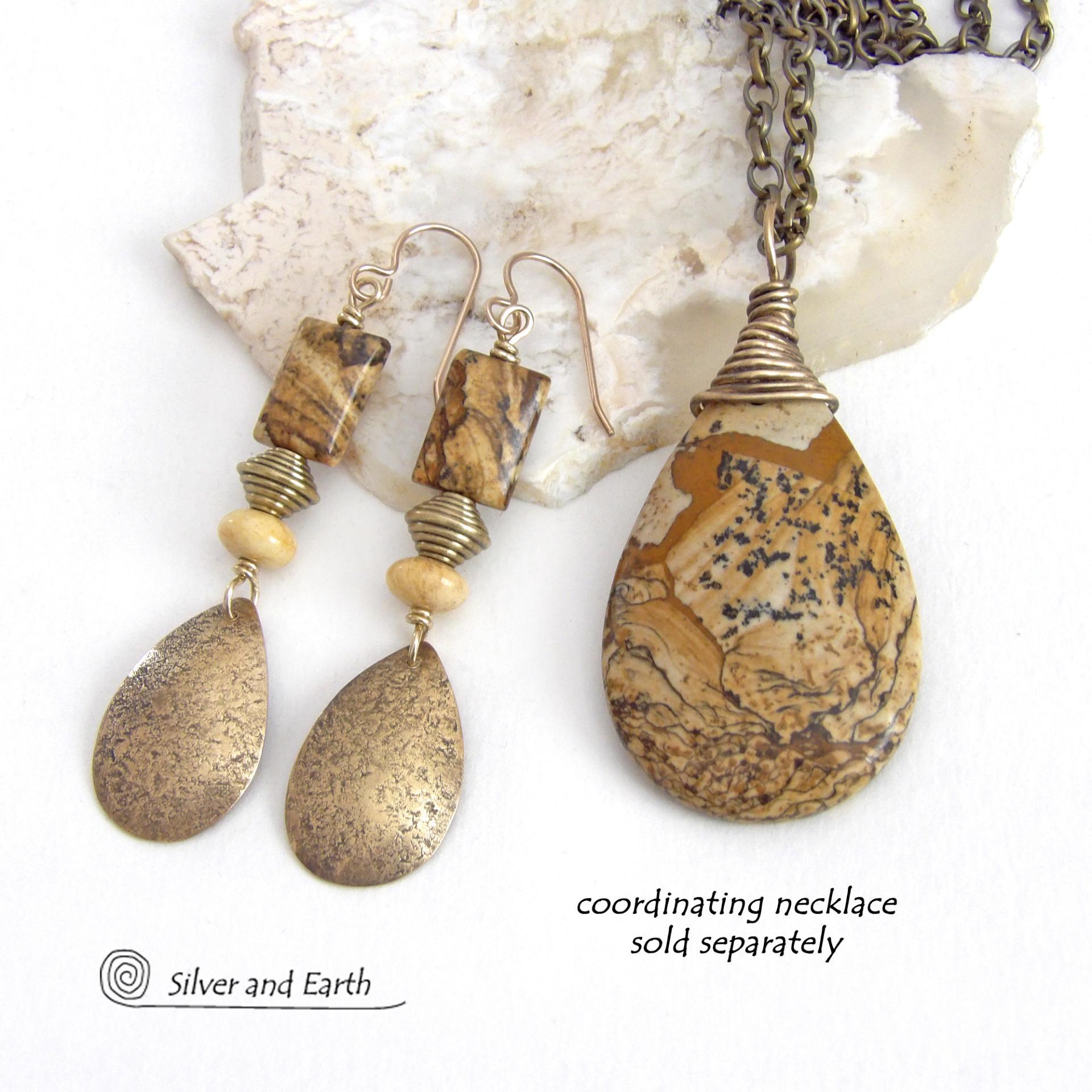 These handcrafted earrings feature gold brass teardrop dangles with a lightly hammered organic texture accented with natural picture jasper stones, brass and fossilized beige coral beads. They have an earthy natural style that coordinates beautifully with all wardrobe styles. Earrings have a coordinating necklace sold separately. Handmade in the USA by Silver and Earth Jewelry.