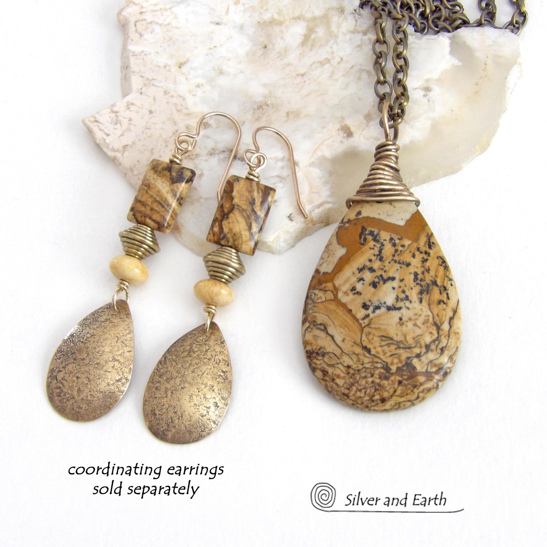 This one-of-a-kind necklace features a natural picture jasper stone wrapped in gold brass wire. The stone has an interesting matrix pattern with earthy hues of brown, tan and black. It has an earthy, simple style that coordinates beautifully with all wardrobe styles. It makes a great gift for a natural stone lover - or a nice addition to your own jewelry collection. Handmade in the USA by Silver and Earth Jewelry. Coordinating earrings sold separately.