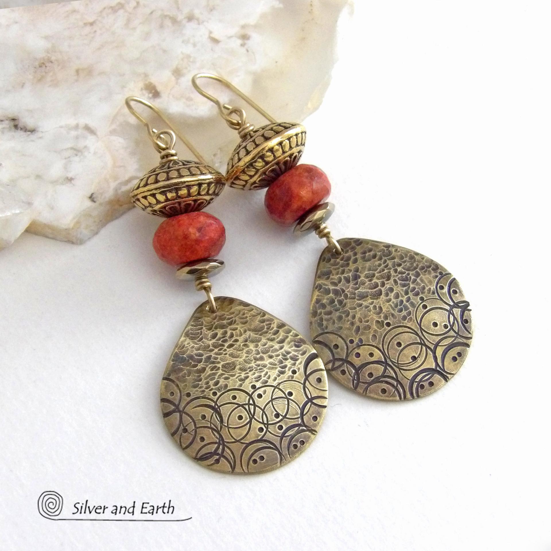 These handcrafted gold brass earrings have a hand stamped and hammered texture and are accented with faceted red coral, brass tribal style beads and faceted hematite stone beads with an electroplated champagne gold tone finish. Big and bold, they have a modern boho chic vibe with a tribal flair that makes a striking statement. Perfect for women that love to wear unique and eye-catching artisan handcrafted jewelry. Handmade in the USA by Silver and Earth Jewelry.