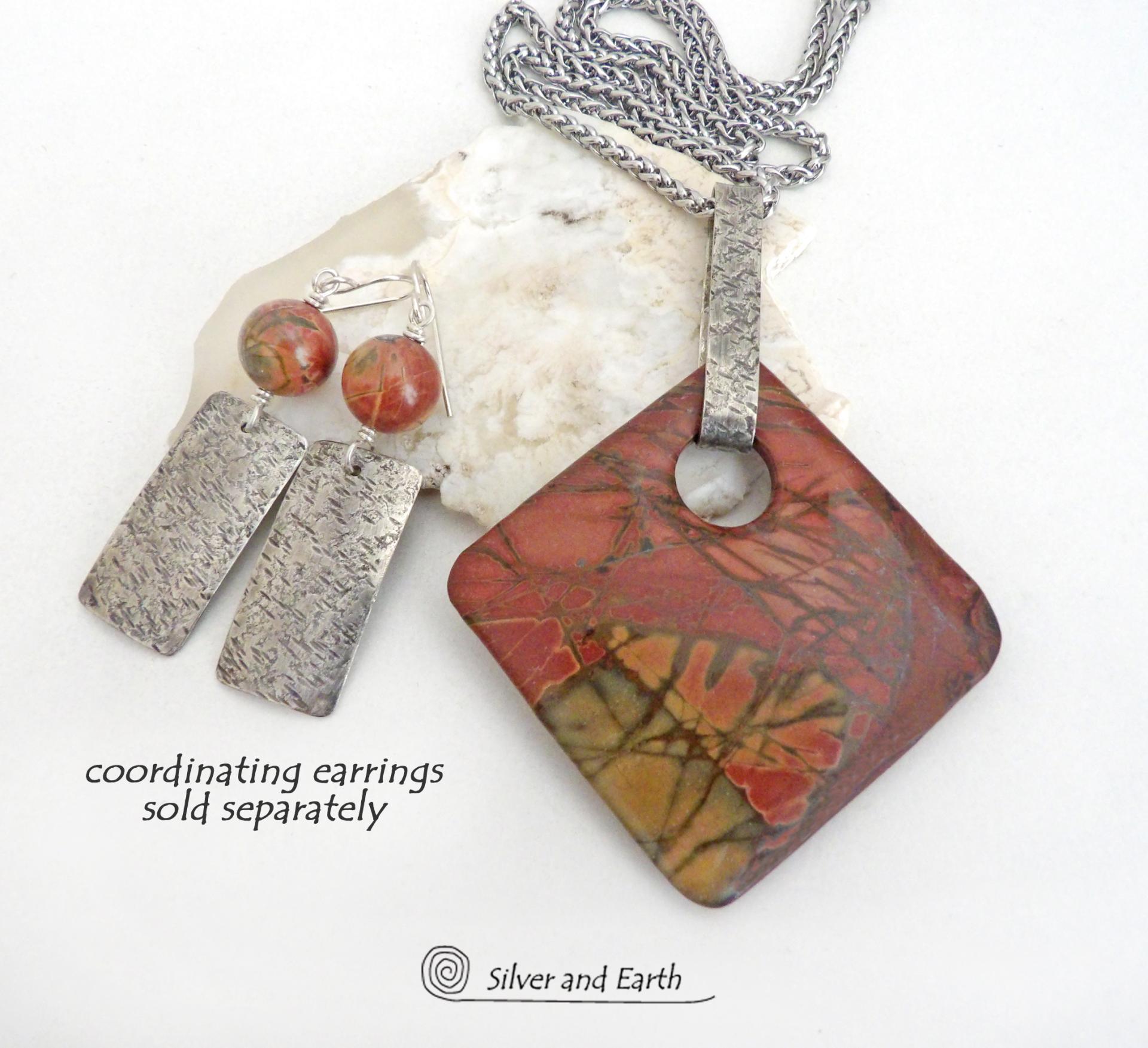 This one-of-a-kind necklace features a natural red creek jasper stone accented with a hand forged sterling silver bail with a lightly hammered texture. The stone has a beautiful natural pattern in earthy hues of mossy greens, brick red, brown and orange. It's reversible and can be worn on either side. It makes a great gift for anyone that loves earthy colors and natural stones. The design is unisex so it could be worn by a man or woman. Coordinating earrings sold separately. 
