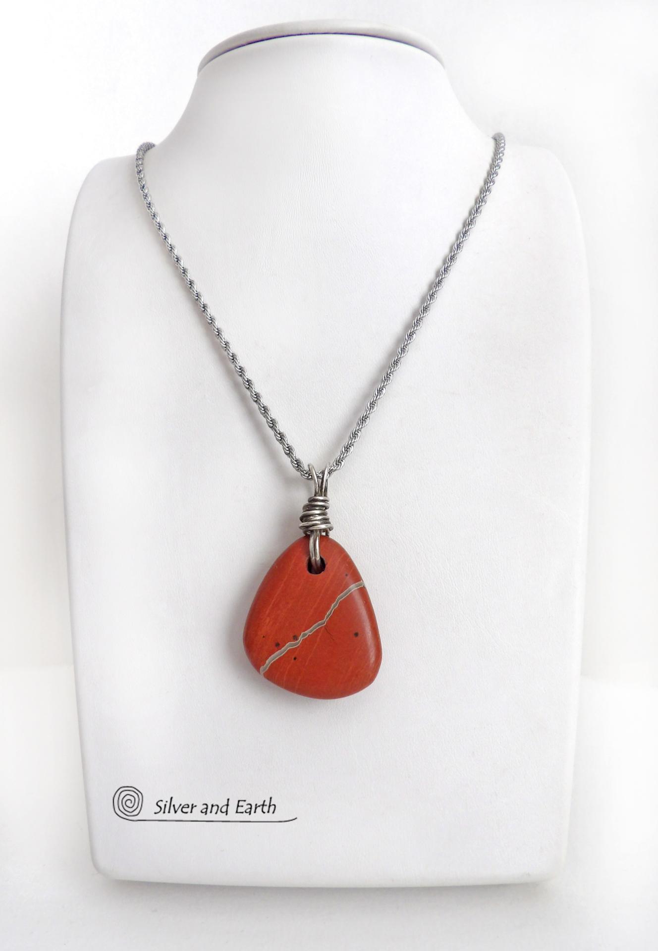 Simple and earthy - this pendant necklace features a natural red jasper gemstone with a wire wrapped sterling silver bail. The stone has a brick red hue with a natural matrix of beige streaks and dots. It has a modern minimalist appeal and is perfect for those that prefer simple, earthy jewelry. It has coordinating earrings which are sold separately. It makes a great gift for a natural stone lover - or a nice addition to your own jewelry wardrobe. Handmade in the USA by Silver and Earth Jewelry. 