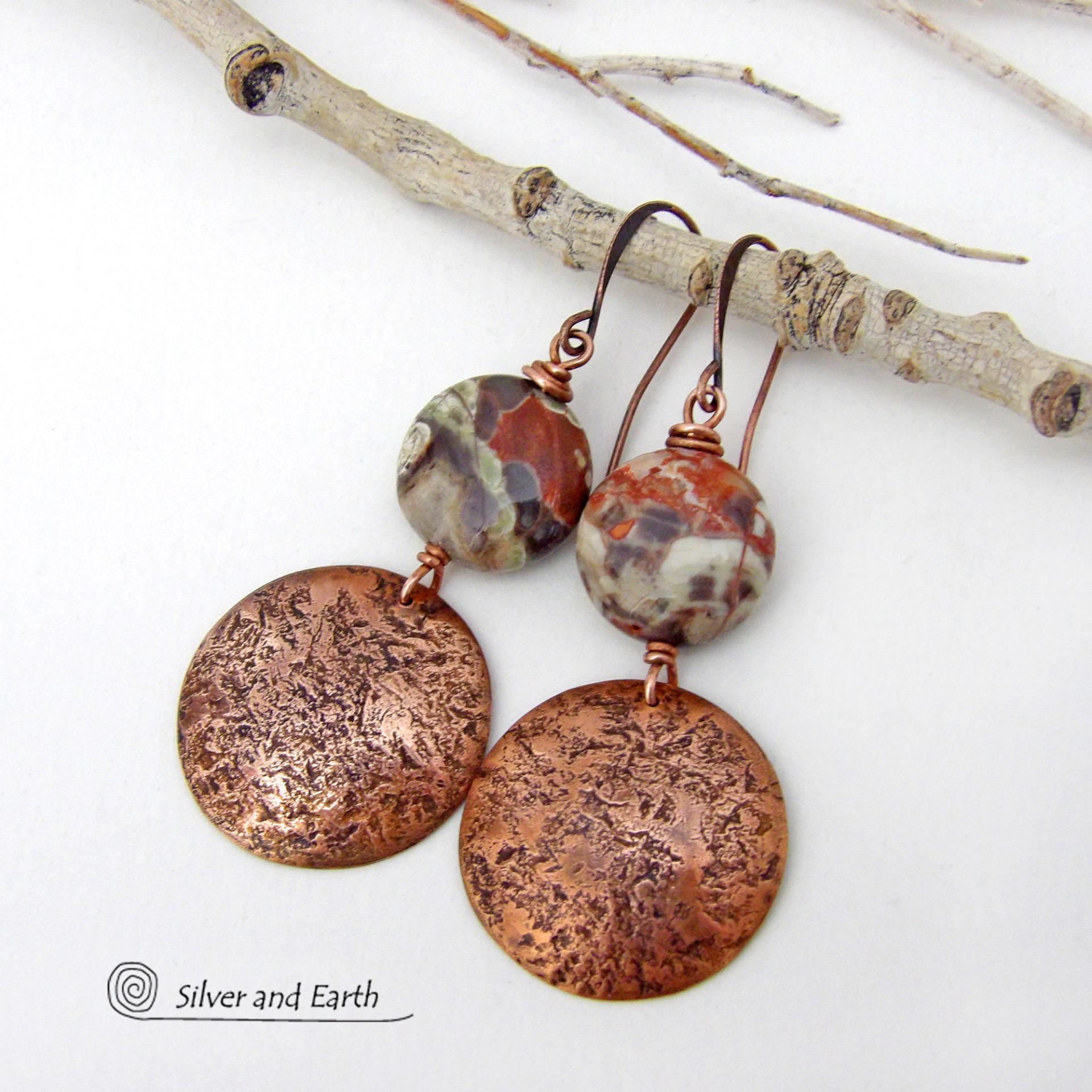 These handcrafted earrings feature natural rhyolite jasper stones accented with copper dangles with a rustic hammered texture. The stones have a natural earthy pattern with various shades of green, rusty orange, brown and cream. They have a casual and earthy style and will make a great gift for a natural stone lover - or a nice addition to your own jewelry wardrobe. Your choice of ear wires. Coordinating necklace sold separately. Handmade in the USA by Silver and Earth Jewelry.