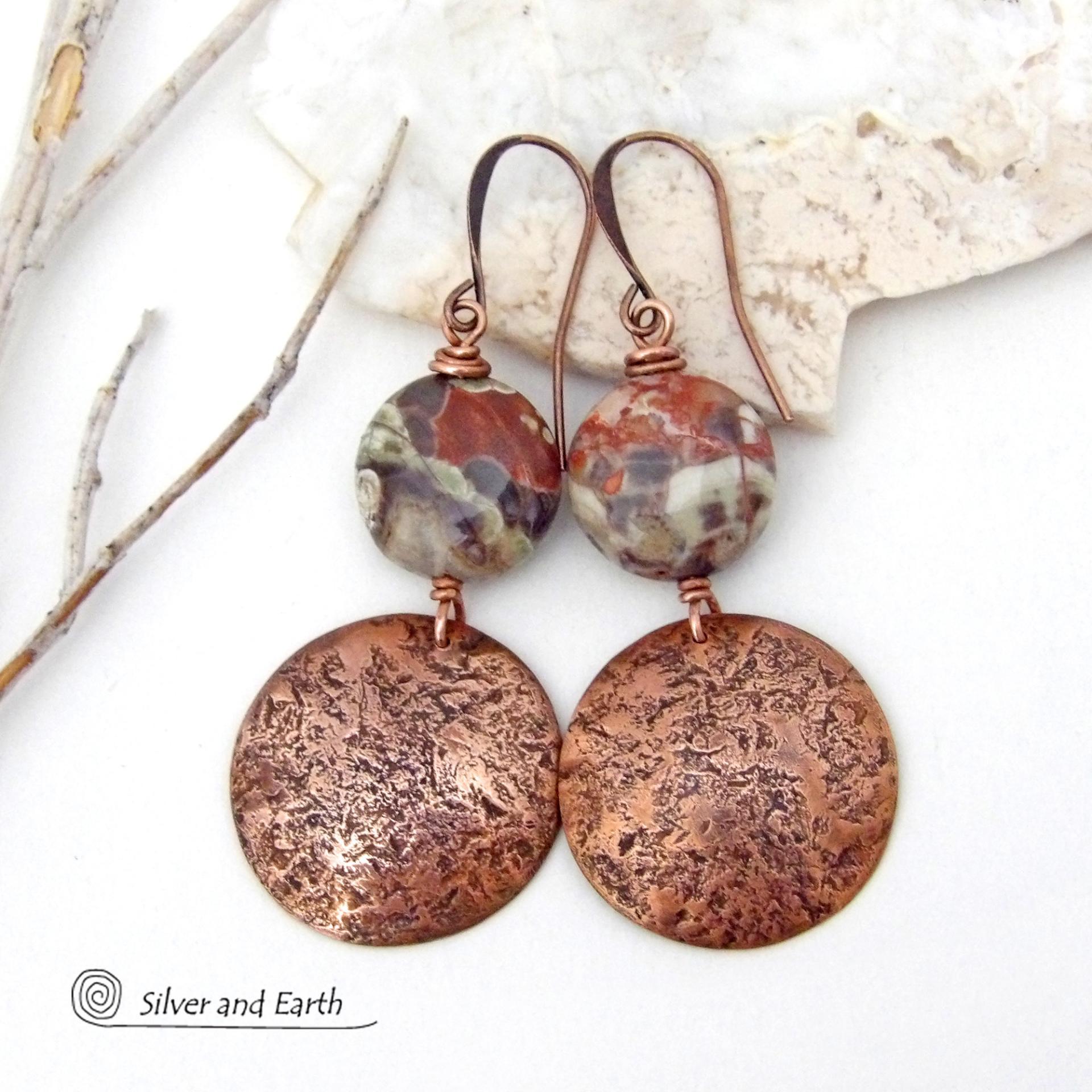 These handcrafted earrings feature natural rhyolite jasper stones accented with copper dangles with a rustic hammered texture. The stones have a natural earthy pattern with various shades of green, rusty orange, brown and cream. They have a casual and earthy style and will make a great gift for a natural stone lover - or a nice addition to your own jewelry wardrobe. Your choice of ear wires. Coordinating necklace sold separately. Handmade in the USA by Silver and Earth Jewelry.