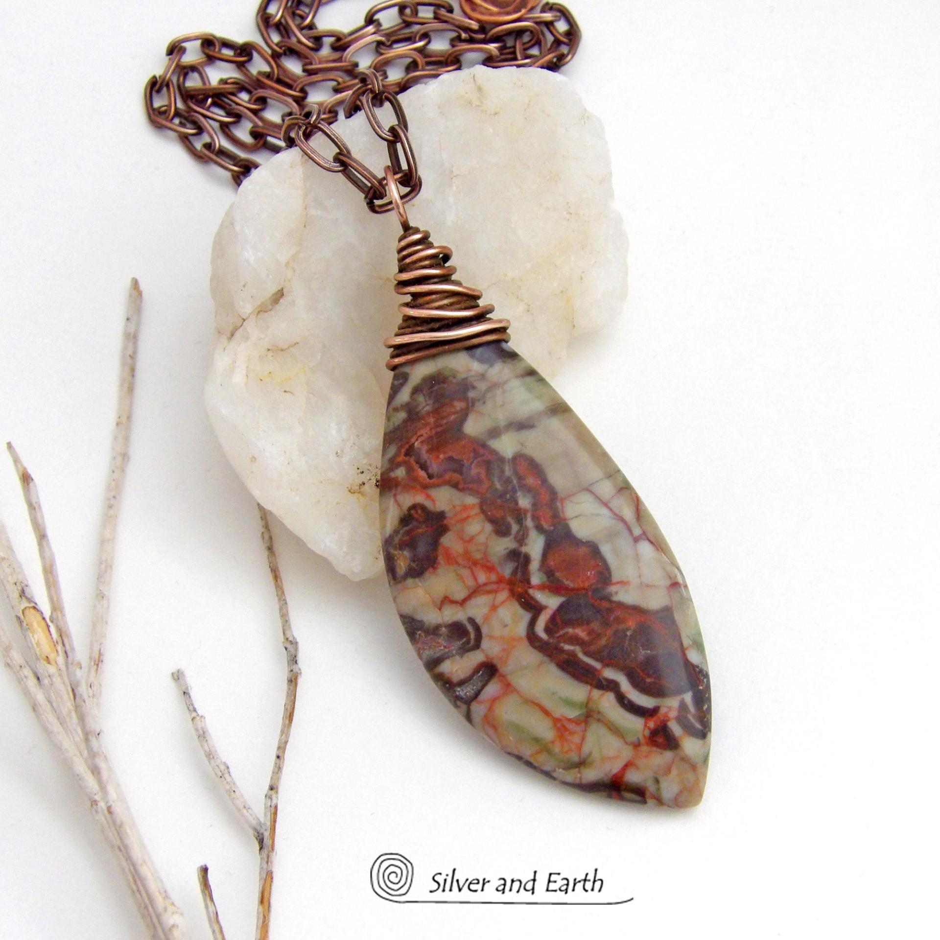 This necklace features a natural rhyolite jasper stone with a natural pattern in earthy hues of rusty orange, brown and taupe. It is wrapped in oxidized copper wire and comes on an 18" copper chain necklace. It has an earthy, natural style and will make a great gift for a natural stone lover - or a nice addition to your own jewelry collection. The chain can be removed from the pendant and worn with other pendants in your wardrobe. Coordinating earrings sold separately. 