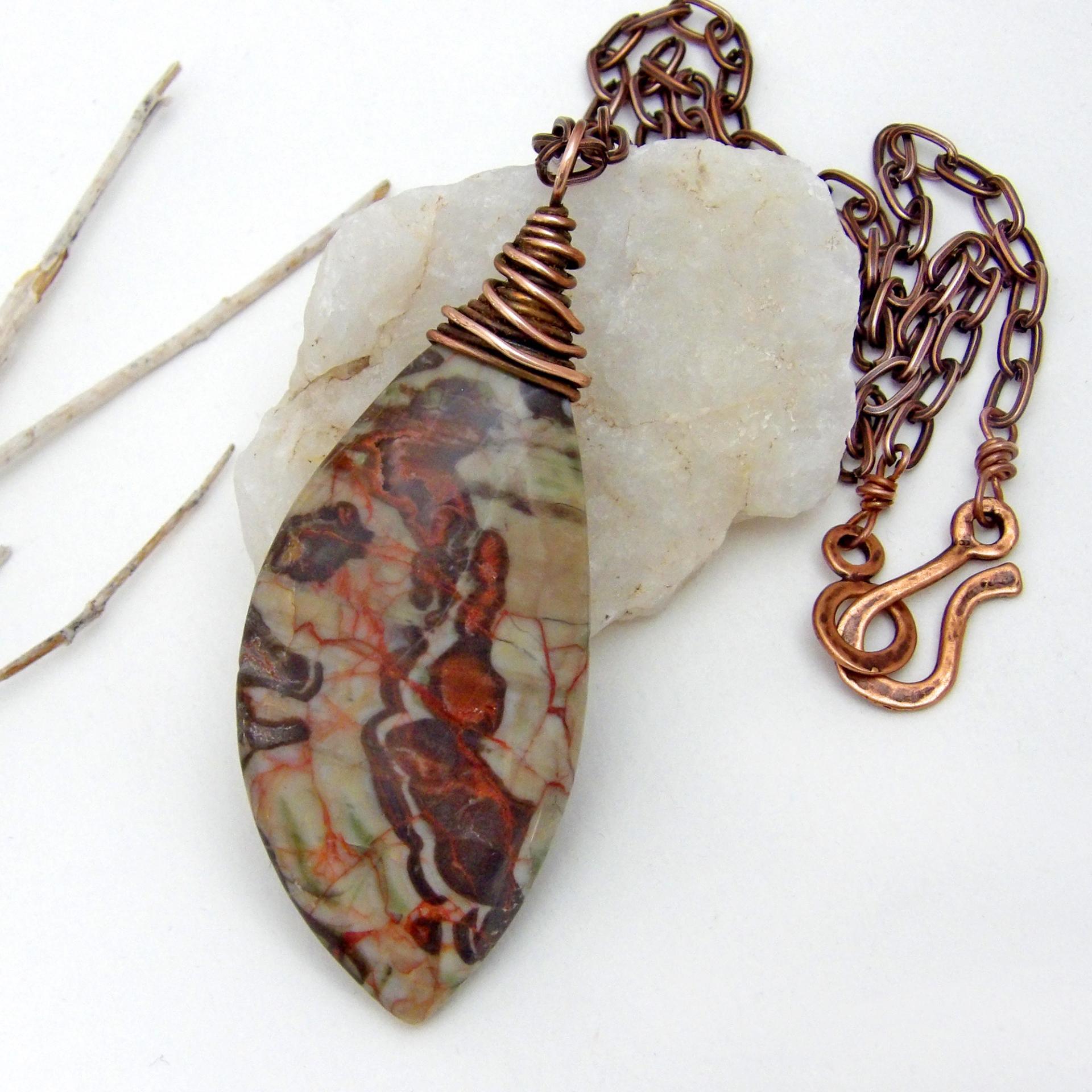 This necklace features a natural rhyolite jasper stone with a natural pattern in earthy hues of rusty orange, brown and taupe. It is wrapped in oxidized copper wire and comes on an 18" copper chain necklace. It has an earthy, natural style and will make a great gift for a natural stone lover - or a nice addition to your own jewelry collection. The chain can be removed from the pendant and worn with other pendants in your wardrobe. Coordinating earrings sold separately. 