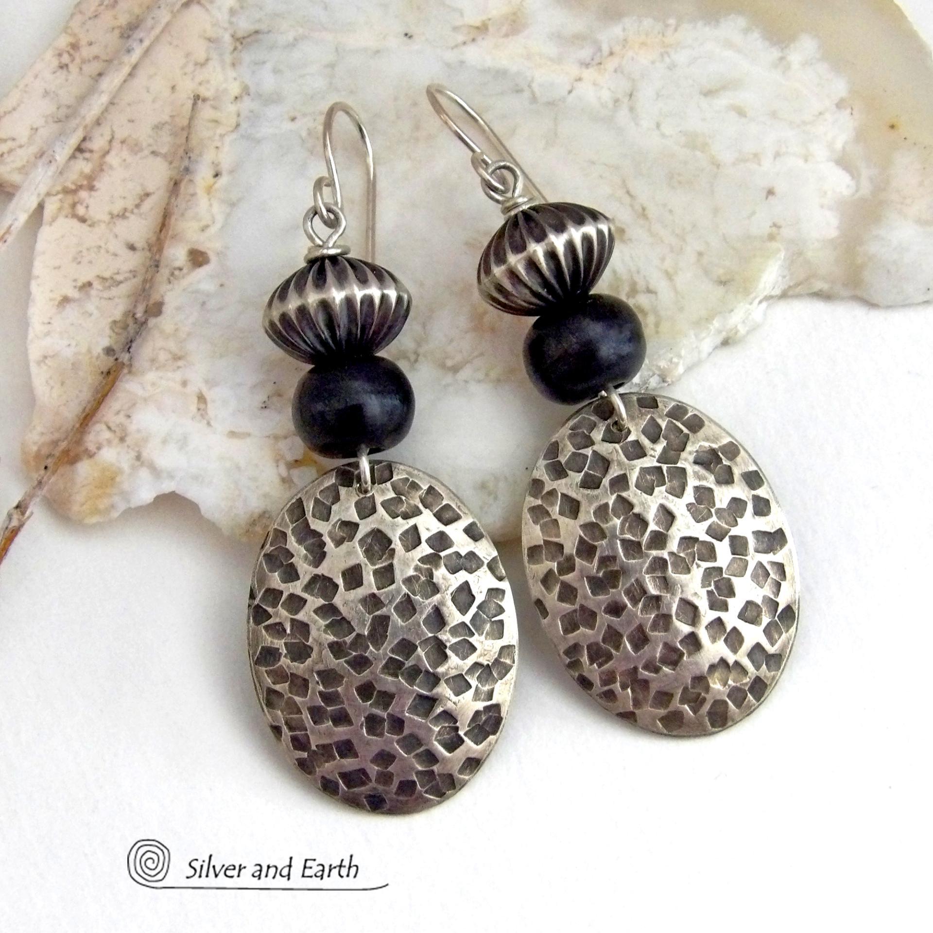 These sterling silver earrings have an earthy, southwestern tribal style. They feature hand textured sterling silver dangles accented with black buffalo horn and Native Navajo pearl style sterling silver beads with a rich, corrugated texture. Unique and striking, they'll make a bold statement. Handmade in the USA by Silver and Earth Jewelry. 