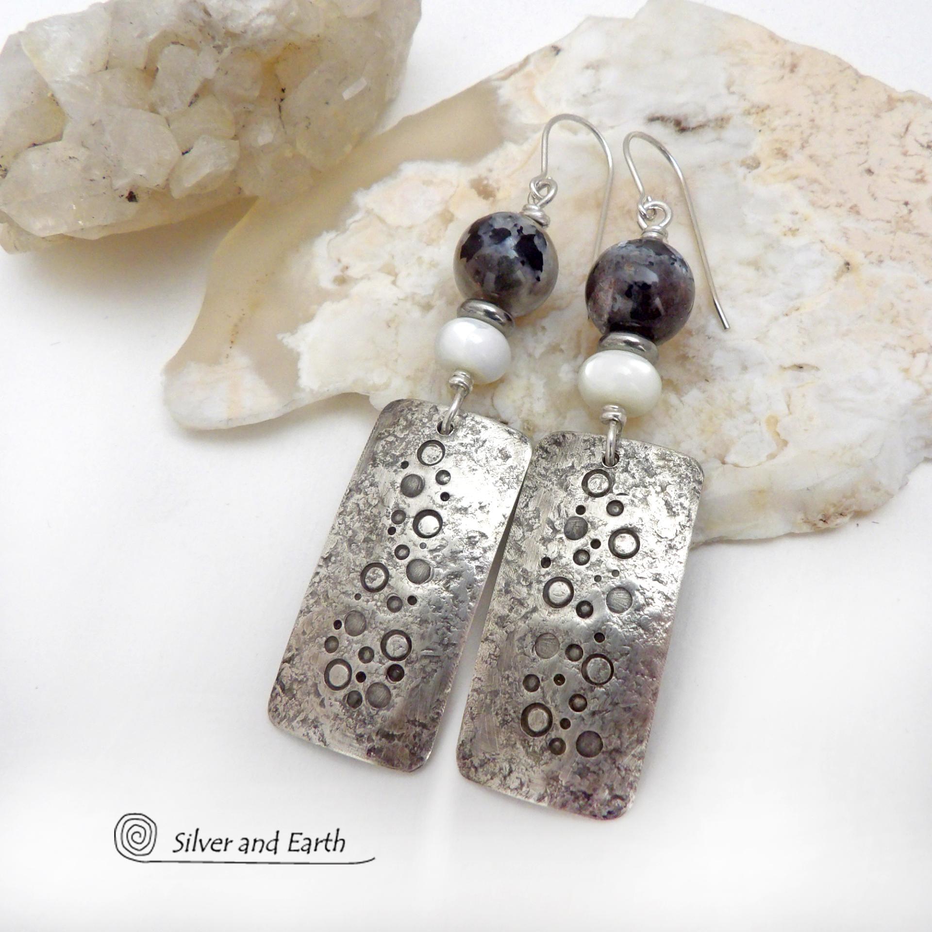 These handcrafted sterling silver earrings have a hand stamped and lightly hammered organic texture and are accented with natural sunstone / moonstone gemstones and mother of pearl and small stainless steel beads. This hybrid stone is rare and found only in Tanzania. It has beautiful shimmery hues of black with natural silvery flashes and subtle peach and gold inclusions. These earrings have a modern, elegant chic style that looks great dressed up or down. Perfect for women that love unique gemstone jewelry