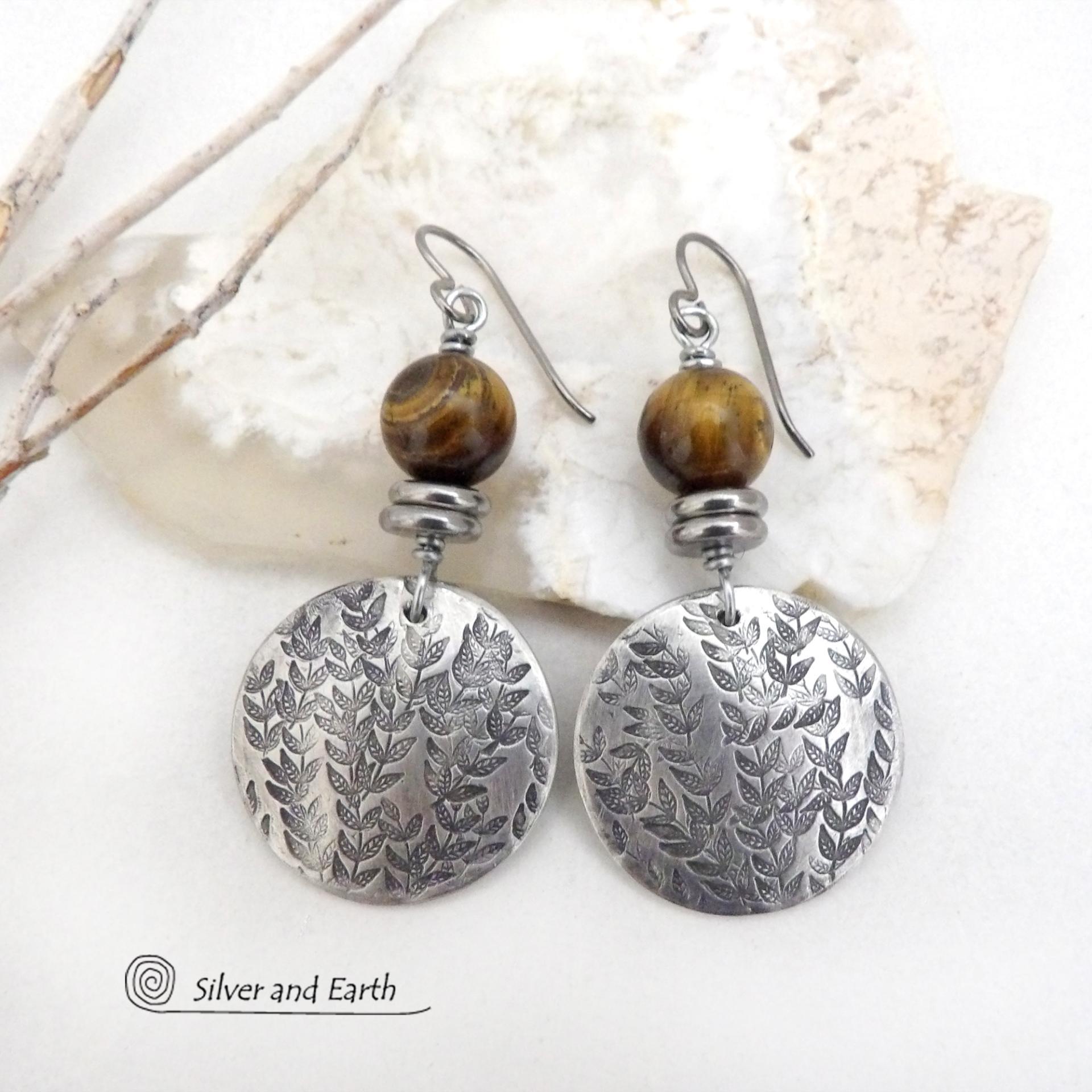 The earrings are handmade and are a beautiful example of nature-inspired jewelry.These handcrafted silver pewter earrings feature a hand stamped leaf design and are accented with brown tiger's eye gemstones and stainless steel beads. They have an earthy, modern and elegant style that coordinates beautifully with all wardrobe types. They'll make a great gift for a nature lover - or a nice addition to your own jewelry wardrobe. 