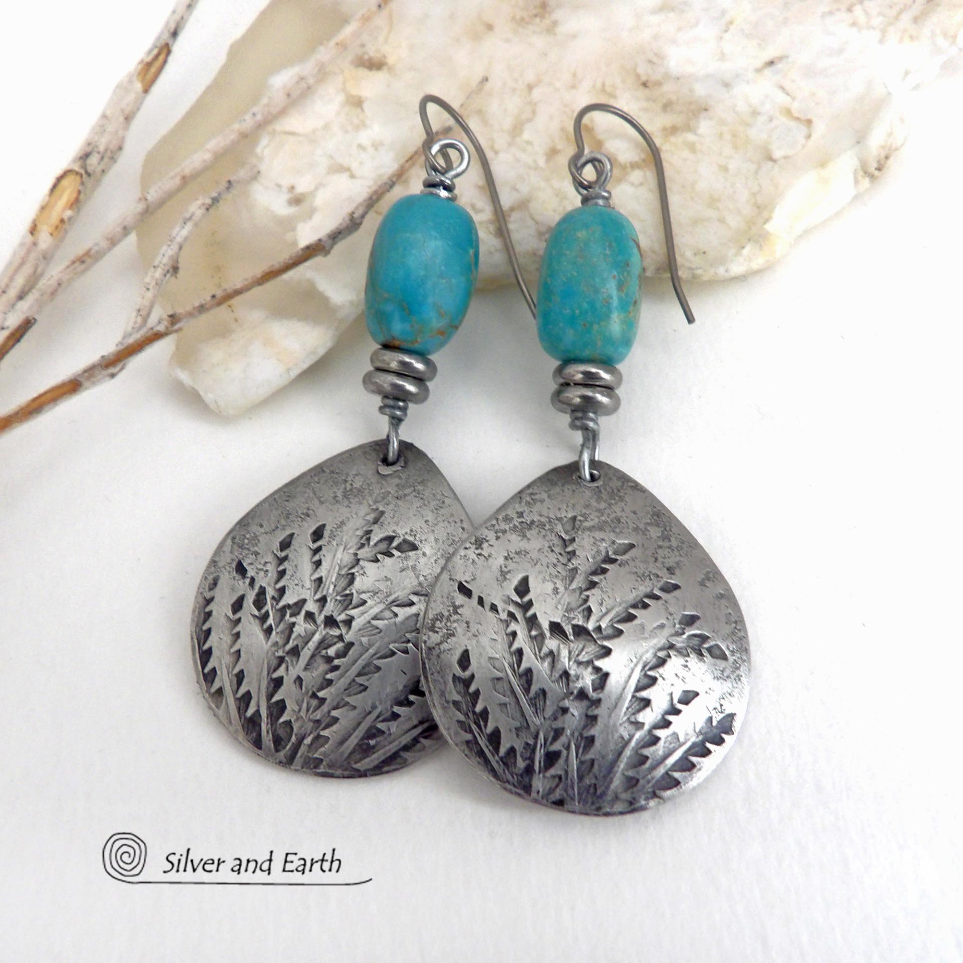 These handcrafted earrings feature silver pewter teardrop-shaped dangles with a hand stamped feather texture accented with natural turquoise stones and small stainless steel beads. They have a modern earthy style with lots of boho chic southwestern flair. They'll make a great gift for anyone that loves natural turquoise stones and southwest style jewelry. Handmade in the USA by Silver and Earth jewelry, a NM True Certfied Business. 