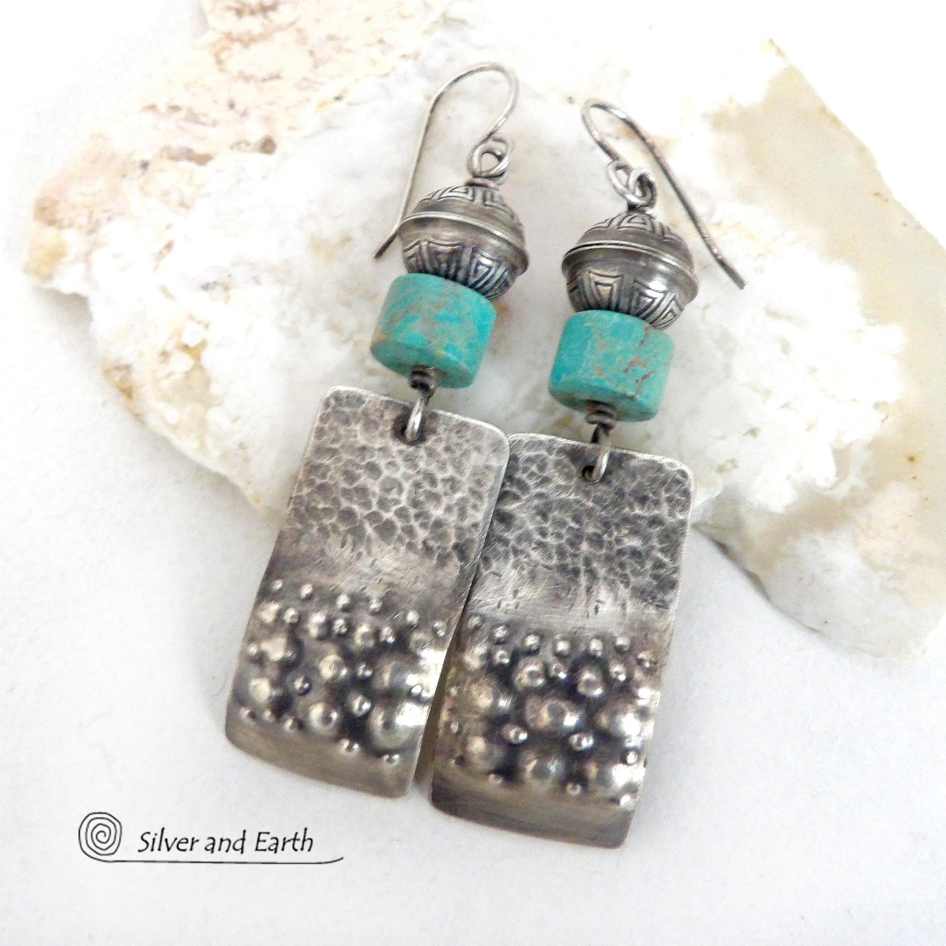 Artisan handcrafted earrings featuring sterling silver rectangles with a hammered and hand stamped texture accented with natural turquoise stones and topped off with oxidized and stamped Native American made sterling silver beads. They have a modern, southwest tribal style and will make a bold statement. Perfect for anyone that loves southwest style jewelry. Handmade in New Mexico by Silver and Earth, a New Mexico Certified True company. 