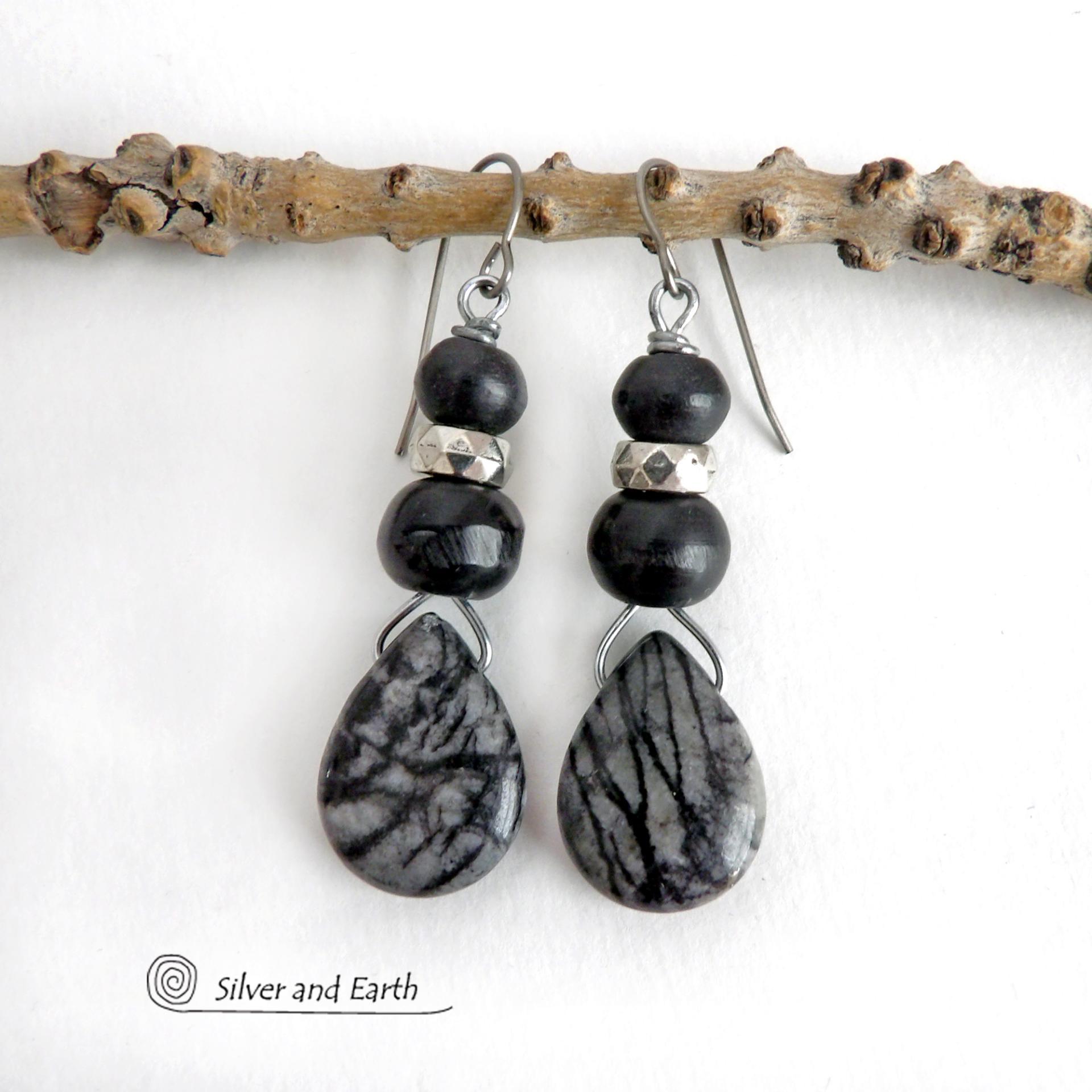 The earrings feature natural zebra jasper stones accented with black beads and silver plated beads and dangle from hypoallergenic titanium ear wires. This stone is known as zebra jasper because of the natural striped matrix that resembles a zebra's pattern. It's a striking stone with earthy hues of soft gray, along with streaks of black. They'll make a great gift for a natural stone lover - or a nice addition to your own jewelry wardrobe. Handmade in the USA by Silver and Earth Jewelry. 