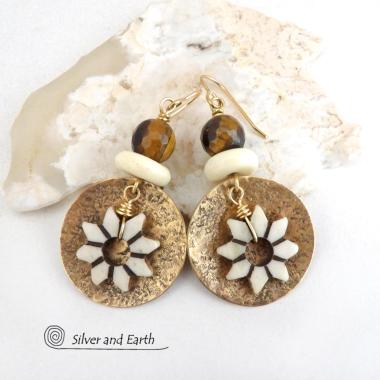 These handmade gold brass earrings have an ethnic bohemian style with an African inspired flair that makes a bold statement. They feature round brass dangles with a lightly hammered texture accented with African flower-shaped bone beads, faceted natural tiger's eye gemstones and African bone beads. Unique and fun to wear, they'll make a great gift for nature lovers and gardeners who love bohemian style jewelry.