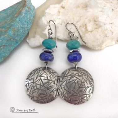 These handcrafted earrings feature sterling silver dangles with a hand stamped texture accented with faceted turquoise and lapis lazuli gemstones. Small hematite gemstones with a faceted finish were added for a touch of natural sparkle and shine. The earrings have a contemporary, modern chic style with a bit of southwestern flair. They'll coordinate beautifully with all wardrobe types - dressed up or down. Handmade in the USA by Silver and Earth Jewelry. 