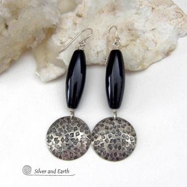 These handcrafted sterling silver dangle earrings have a hand stamped texture and oxidized finish and feature long black onyx gemstones. The stones are cut into a unique, elongated tubular shape and have a rich black hue and high polish. They have a modern, contemporary style that will look great with all wardrobe types. 