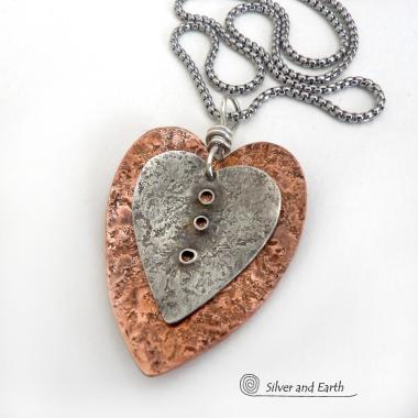 This mixed metal heart necklace has an earthy, rustic charm and will make a great gift for someone special. It features nesting hearts handcrafted from sterling silver and copper. It comes on a 20" stainless steel chain with lobster claw closure. The necklace holds a special significance as it represents two hearts coming together in union. This could be a meaningful gift for someone you love deeply.