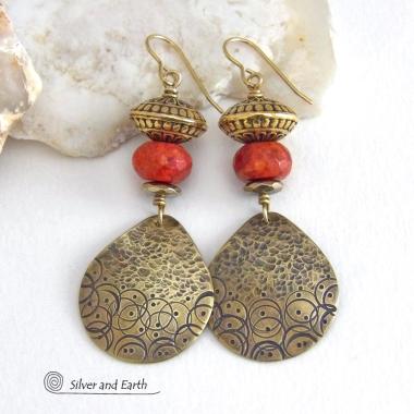 These handcrafted gold brass earrings have a hand stamped and hammered texture and are accented with faceted red coral, brass tribal style beads and faceted hematite stone beads with an electroplated champagne gold tone finish. Big and bold, they have a modern boho chic vibe with a tribal flair that makes a striking statement. Perfect for women that love to wear unique and eye-catching artisan handcrafted jewelry. Handmade in the USA by Silver and Earth Jewelry.