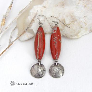 These handmade earrings feature natural red jasper gemstones accented with small hammered sterling silver dangles. The stones have a brick red hue with an interesting matrix of beige streaks and squiggly lines. They have a modern, earthy appeal that coordinates well with all wardrobe styles. They'll make a great gift for a natural stone lover - or a nice addition to your own jewelry wardrobe. They have a coordinating necklace which is sold separately. Handmade in the USA by Silver and Earth Jewelry.  