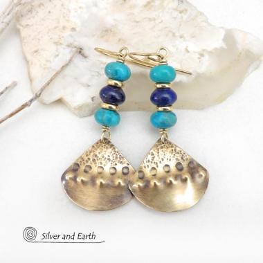 These handcrafted gold brass earrings have a unique hand textured design and are accented with a stack of blue lapis lazuli and turquoise gemstones separated with small brass beads. These handcrafted earrings showcase a unique blend of textures, colors and patterns, perfect for adding a touch of bohemian style to any outfit. 
